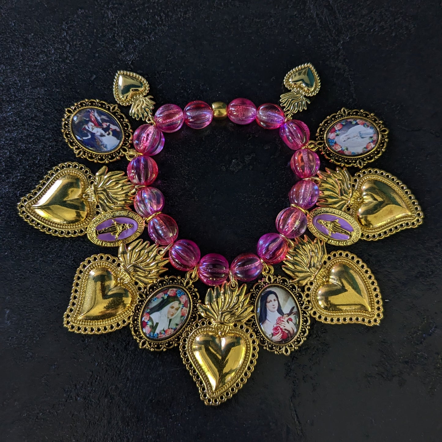 Fait à la main, ce bracelet élégant est orné de médailles catholiques richement détaillées et colorées, et ponctué de médailles miraculeuses.