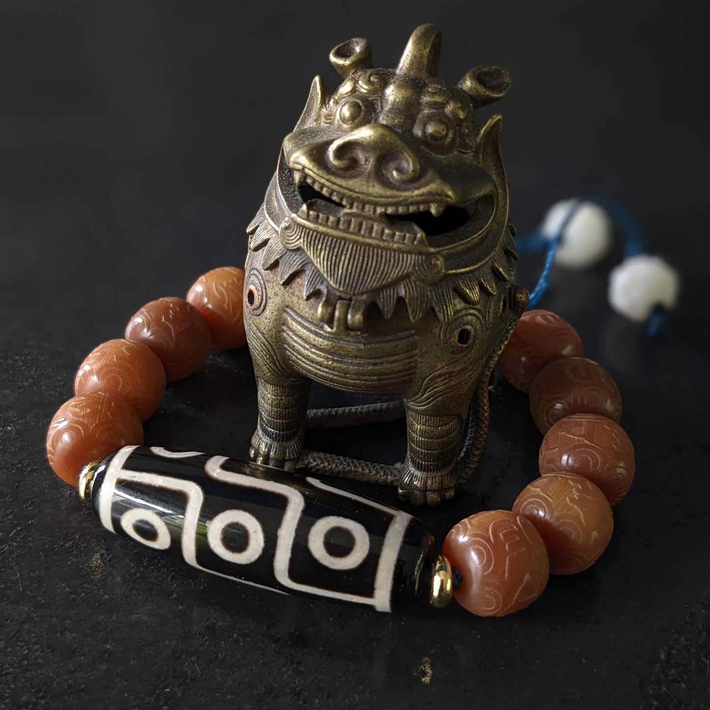 Un bracelet en perles avec mantras et avec une perles Dzi à neuf yeux