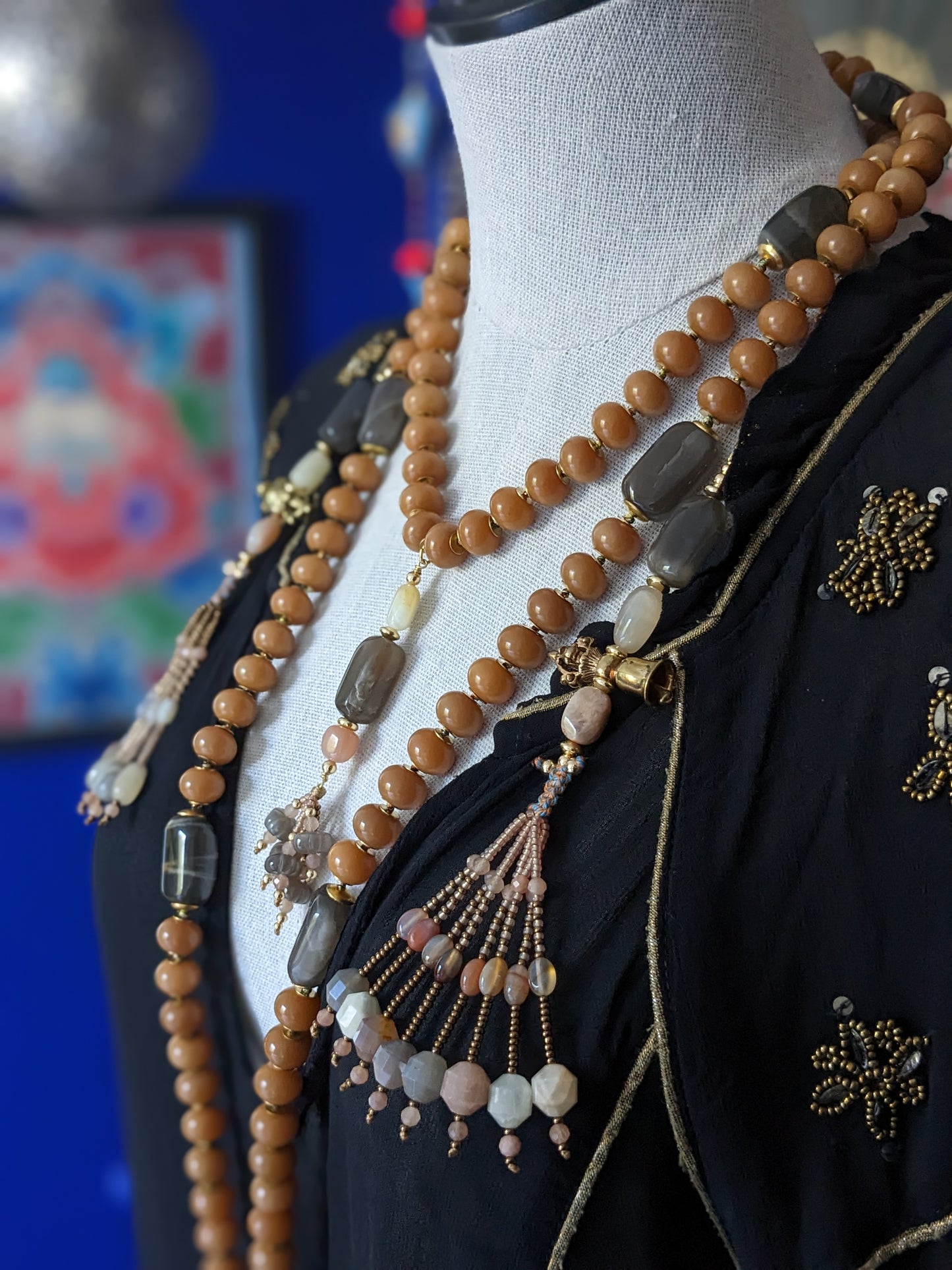Image d'un magnifique collier Mala Ayodhya, soigneusement placé sur une surface en bois rustique sous une lumière douce et chaleureuse, mettant en valeur ses perles de racine de Bodhi miel naturelles et ses perles de pierre de lune grise. Le design complexe et le savoir-faire artisanal du collier sont mis en évidence.