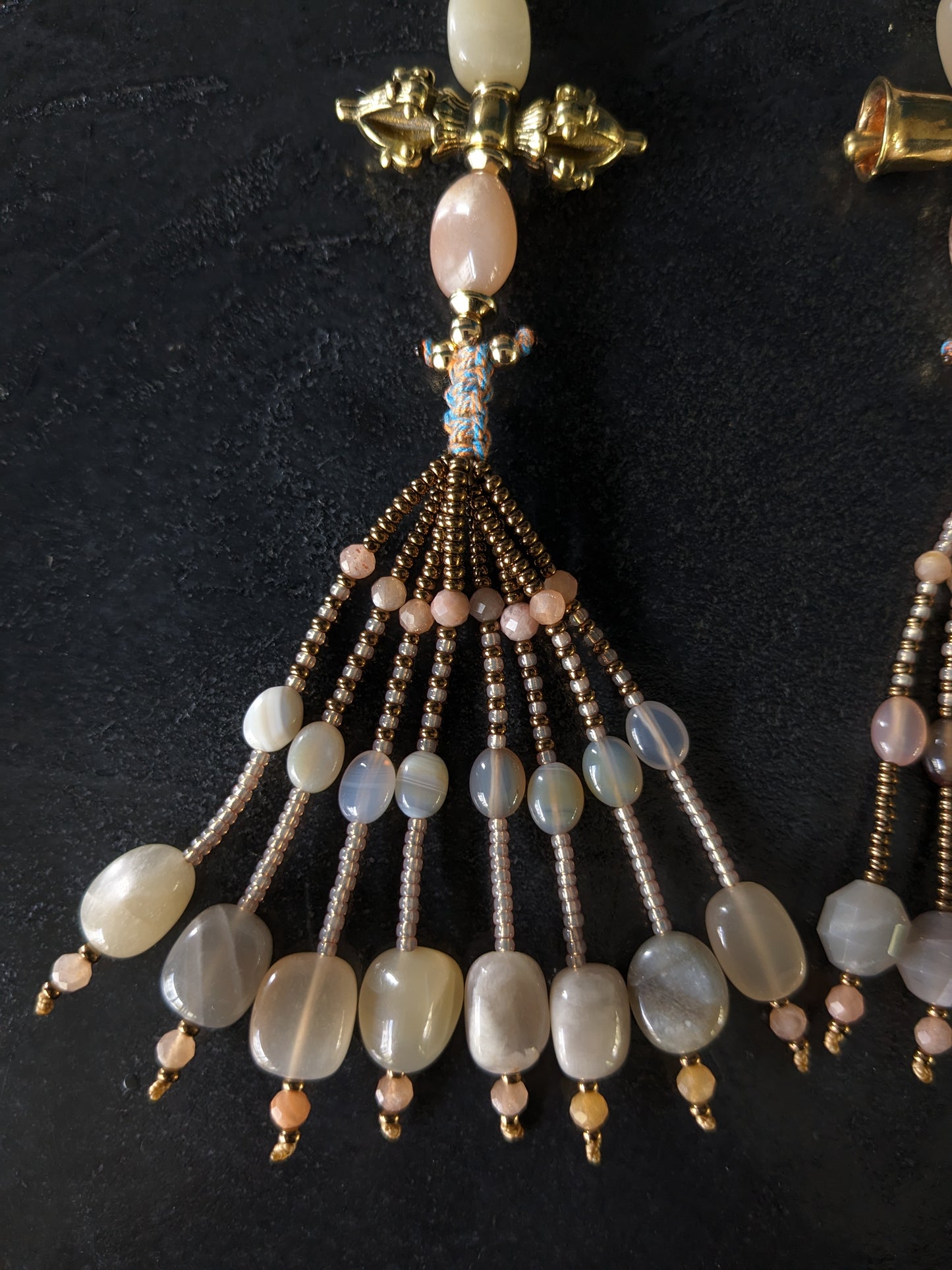 Image d'un magnifique collier Mala Ayodhya, soigneusement placé sur une surface en bois rustique sous une lumière douce et chaleureuse, mettant en valeur ses perles de racine de Bodhi miel naturelles et ses perles de pierre de lune grise. Le design complexe et le savoir-faire artisanal du collier sont mis en évidence.
