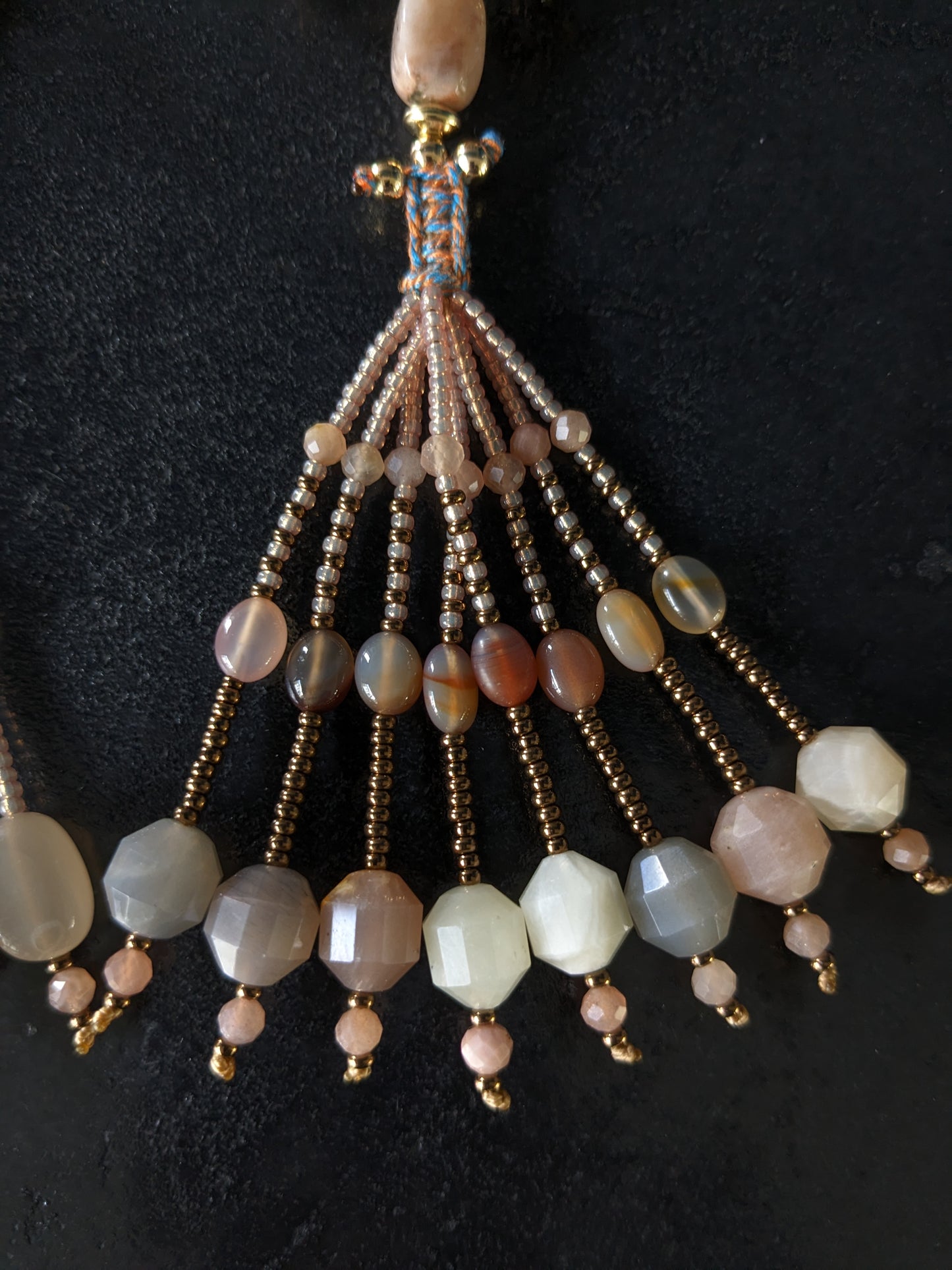 Image d'un magnifique collier Mala Ayodhya, soigneusement placé sur une surface en bois rustique sous une lumière douce et chaleureuse, mettant en valeur ses perles de racine de Bodhi miel naturelles et ses perles de pierre de lune grise. Le design complexe et le savoir-faire artisanal du collier sont mis en évidence.