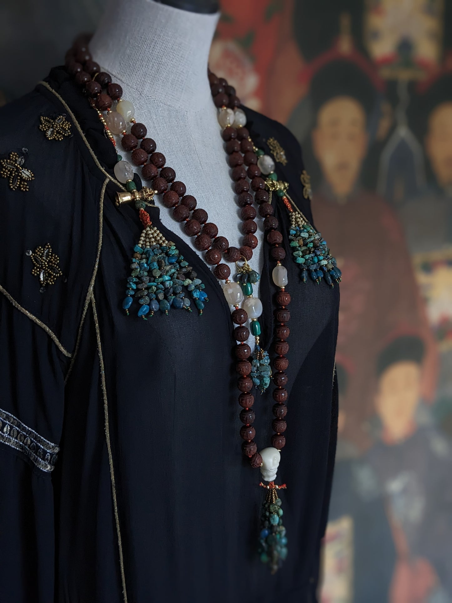 Image captivante du Mala Shambhala, un collier de méditation unique, mettant en valeur ses perles naturelles multicolores et ses compteurs de style tibétain, le tout évoquant une sensation de tranquillité et de profondeur spirituelle.
