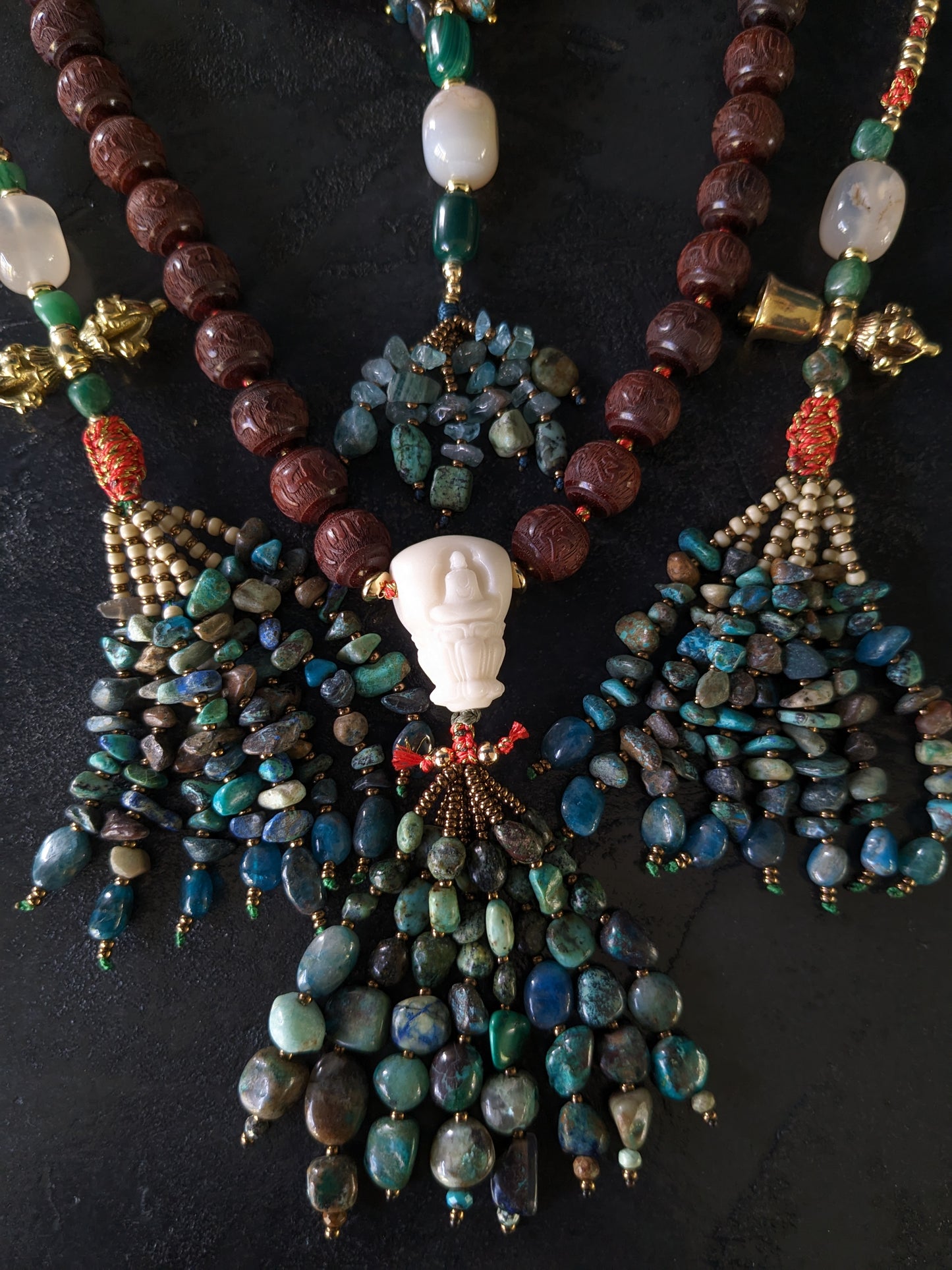 Image captivante du Mala Shambhala, un collier de méditation unique, mettant en valeur ses perles naturelles multicolores et ses compteurs de style tibétain, le tout évoquant une sensation de tranquillité et de profondeur spirituelle.