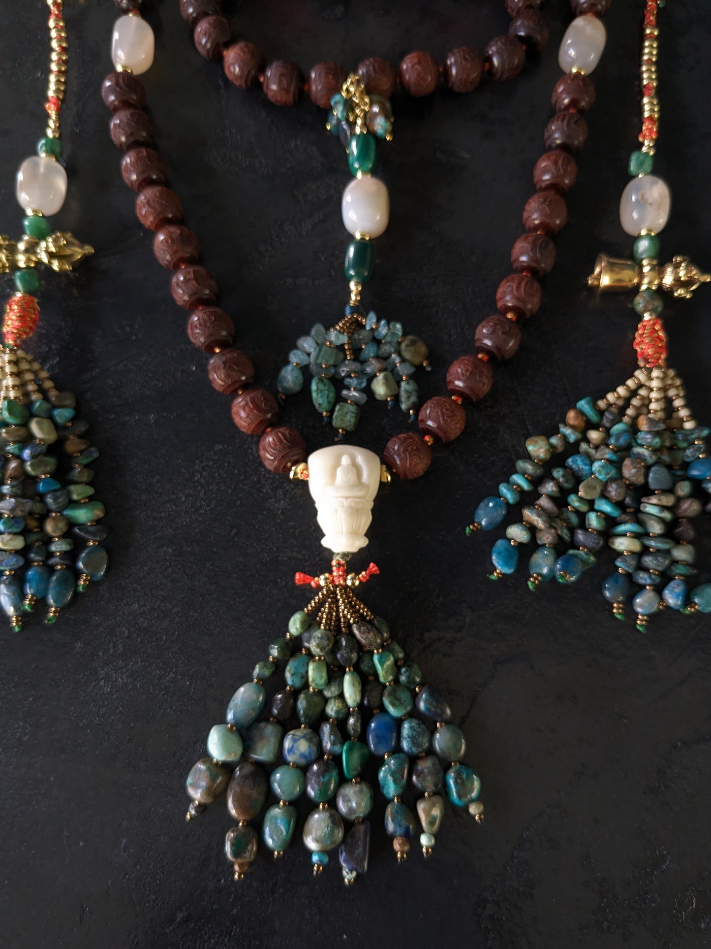 Image captivante du Mala Shambhala, un collier de méditation unique, mettant en valeur ses perles naturelles multicolores et ses compteurs de style tibétain, le tout évoquant une sensation de tranquillité et de profondeur spirituelle.