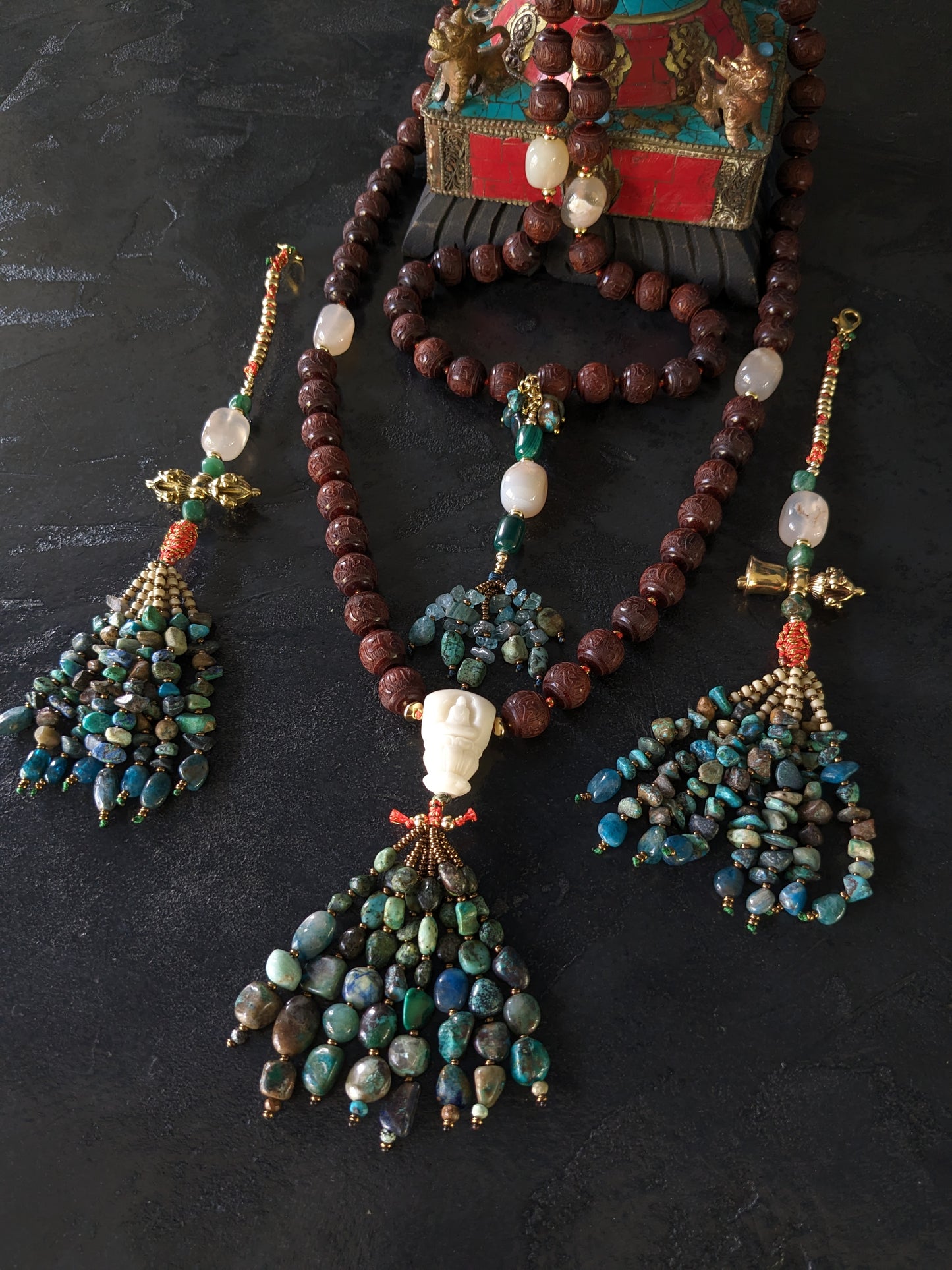 Image captivante du Mala Shambhala, un collier de méditation unique, mettant en valeur ses perles naturelles multicolores et ses compteurs de style tibétain, le tout évoquant une sensation de tranquillité et de profondeur spirituelle.
