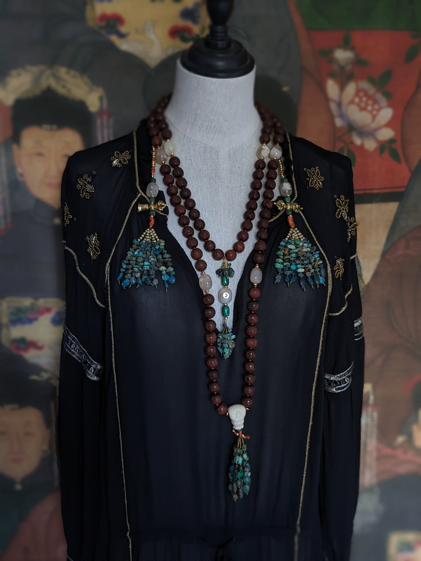 Image captivante du Mala Shambhala, un collier de méditation unique, mettant en valeur ses perles naturelles multicolores et ses compteurs de style tibétain, le tout évoquant une sensation de tranquillité et de profondeur spirituelle.