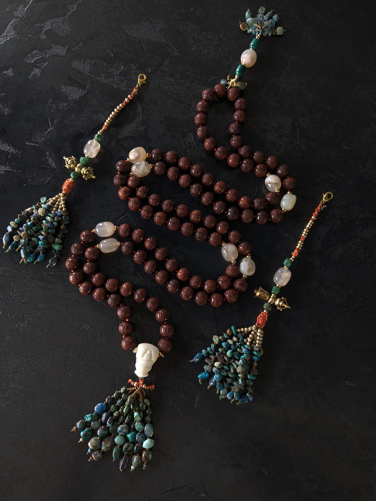 Image captivante du Mala Shambhala, un collier de méditation unique, mettant en valeur ses perles naturelles multicolores et ses compteurs de style tibétain, le tout évoquant une sensation de tranquillité et de profondeur spirituelle.