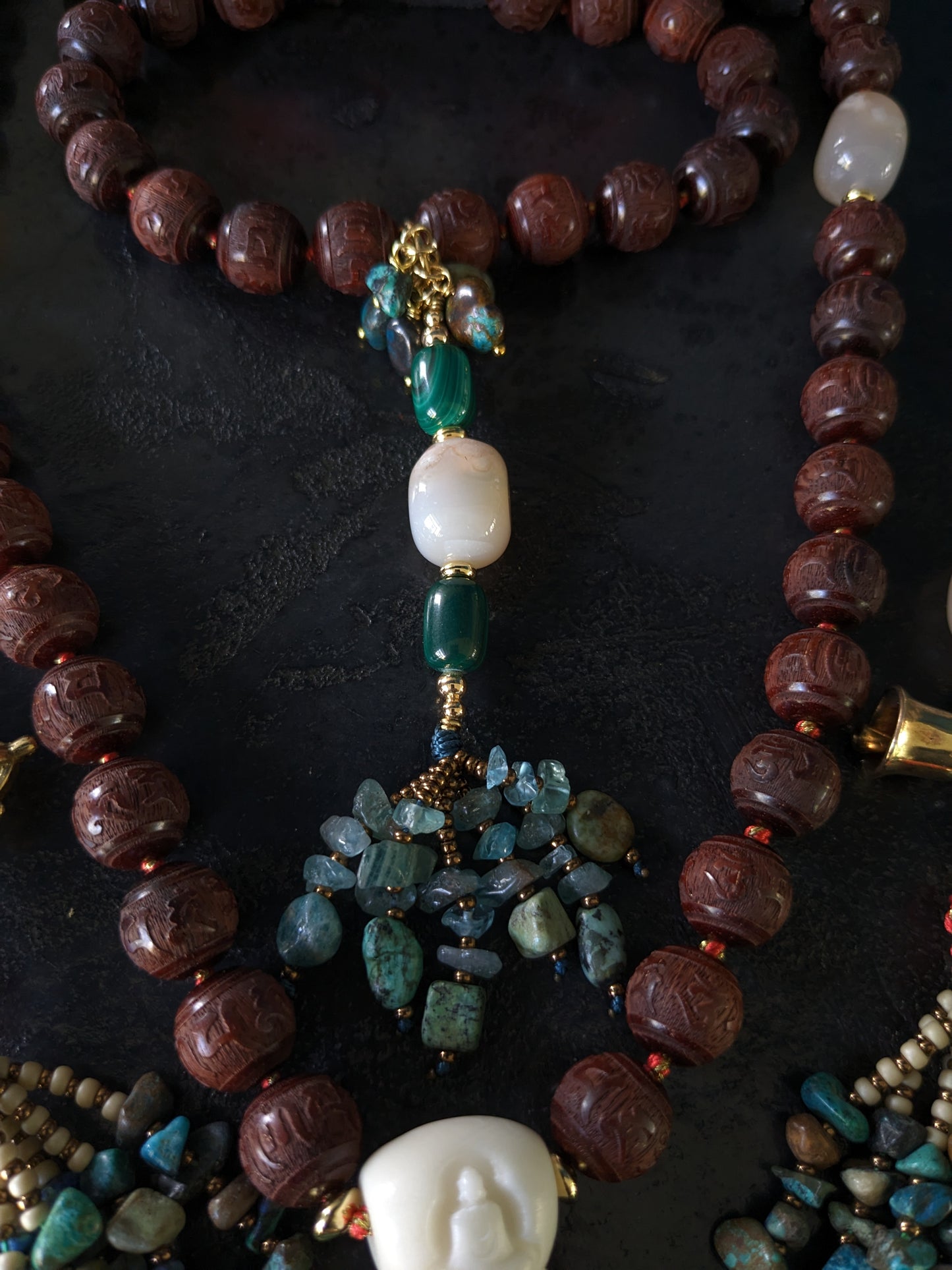 Image captivante du Mala Shambhala, un collier de méditation unique, mettant en valeur ses perles naturelles multicolores et ses compteurs de style tibétain, le tout évoquant une sensation de tranquillité et de profondeur spirituelle.