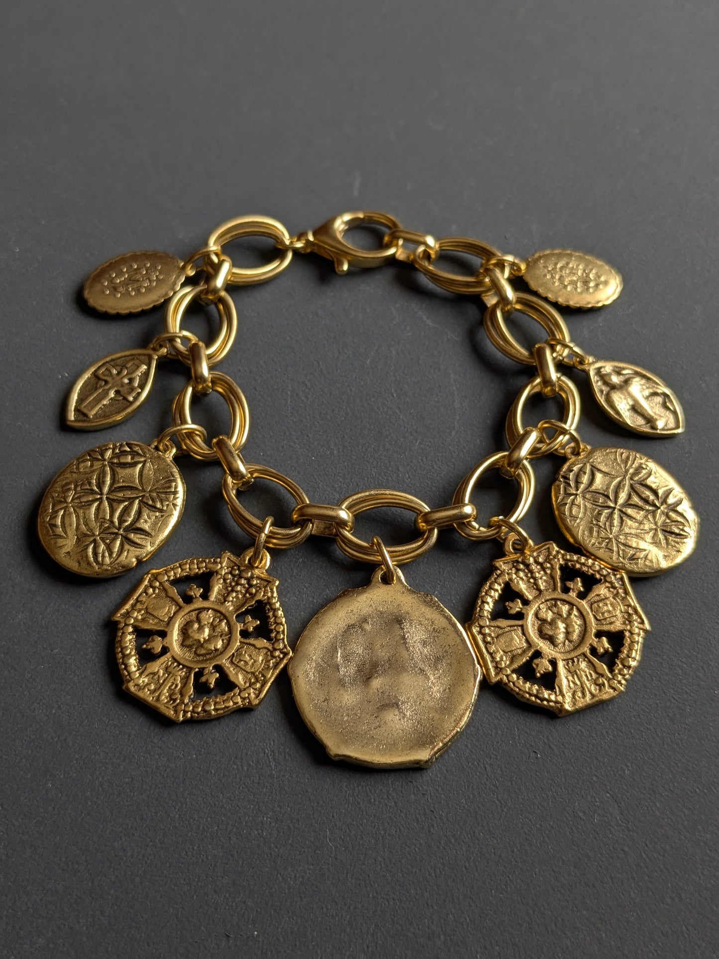 Gros plan sur les médailles réversibles du bracelet Neuvaine par Mudra.