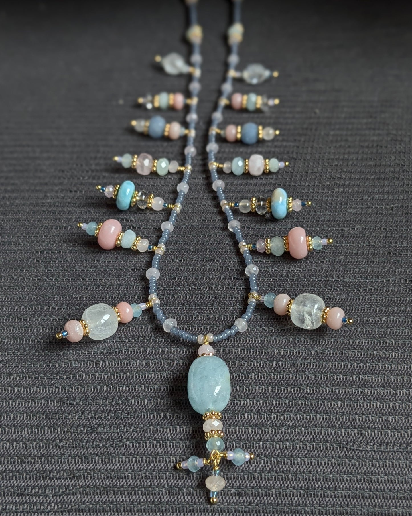 Détail rapproché des rocailles japonaises bleu givré et du jade mauve composant le collier Suryani.