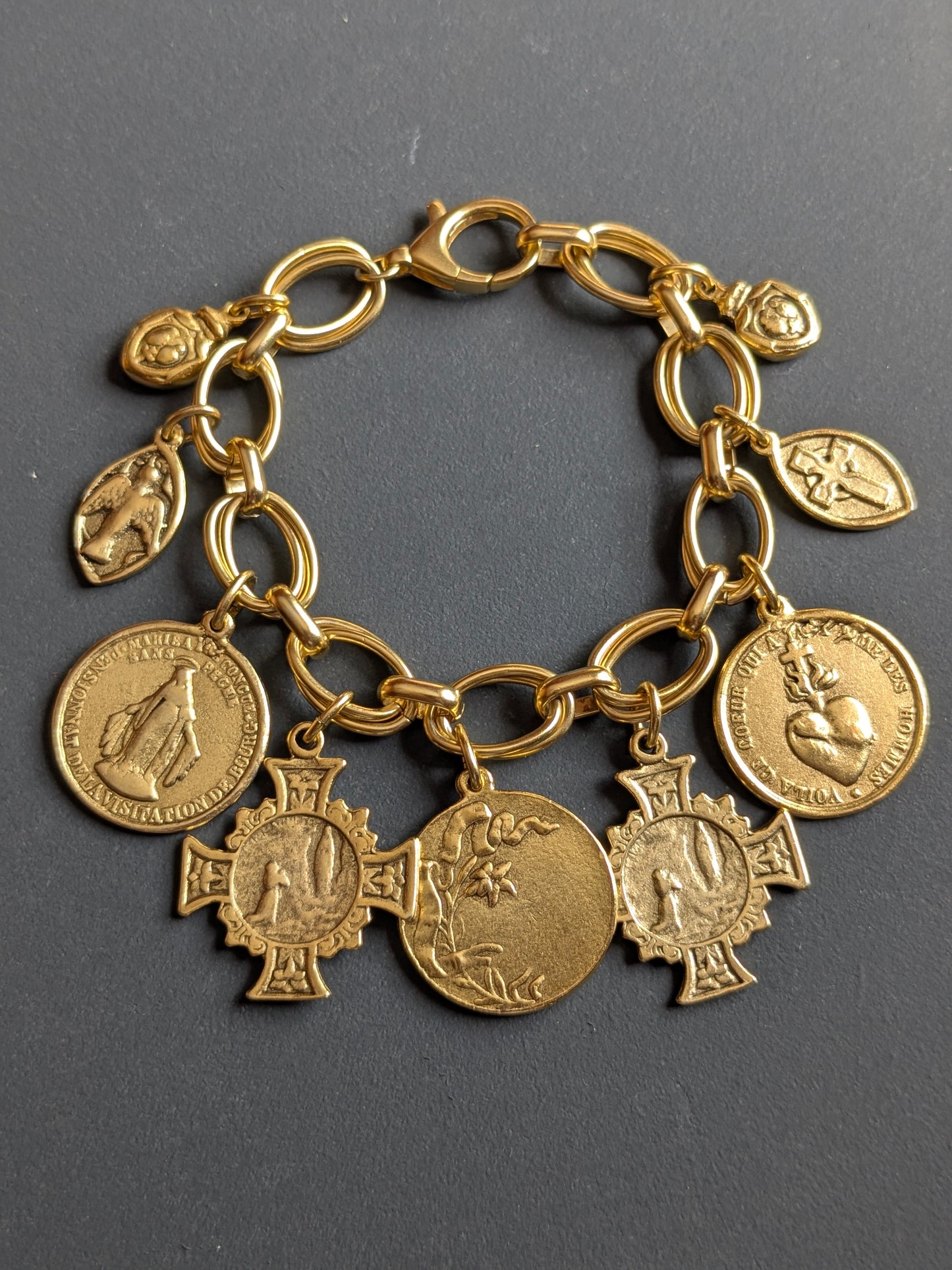 Détail des médailles réversibles Notre-Dame de Lourdes et Rosa Mystica du bracelet Grâce, en laiton plaqué or 12kt.