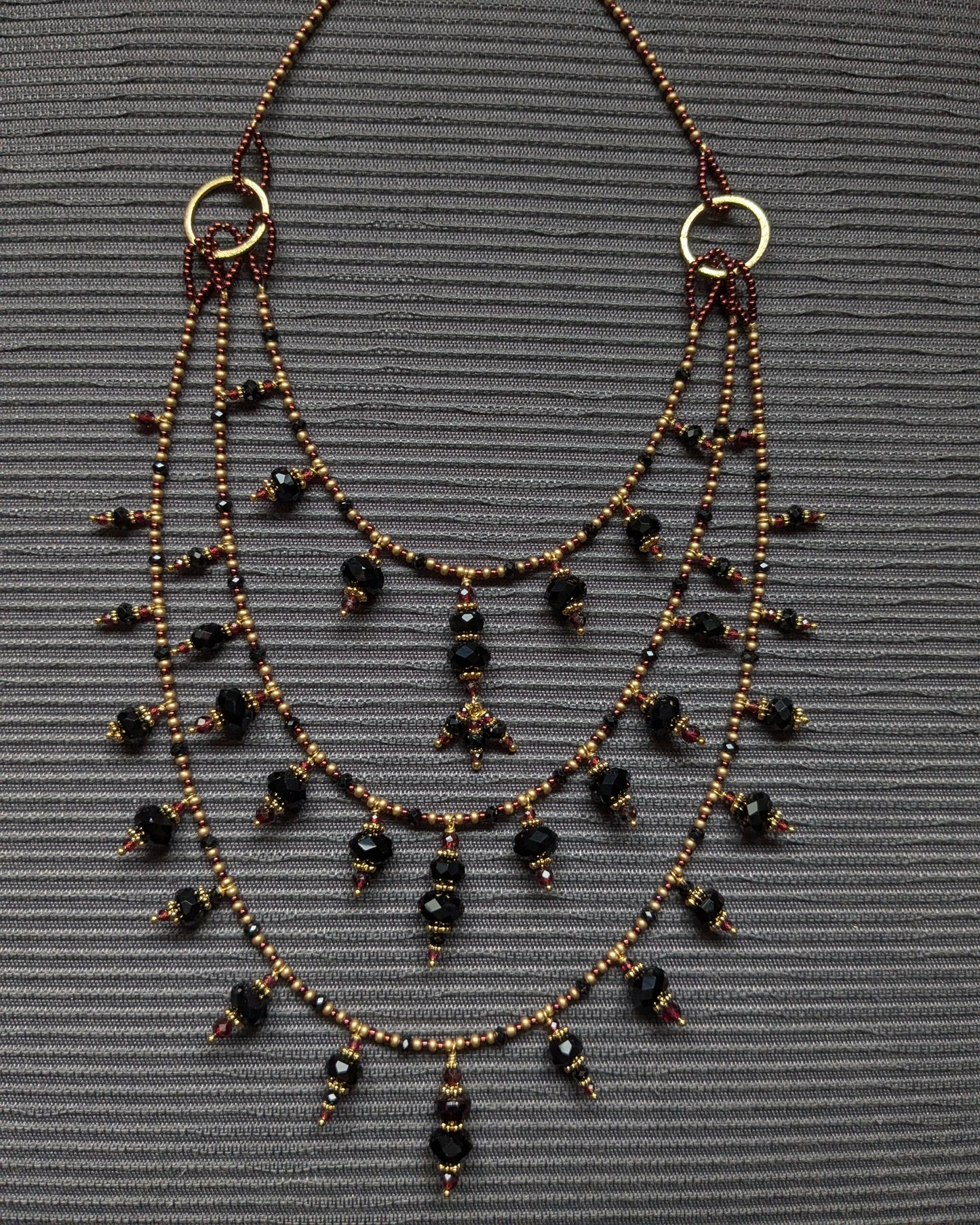 Détail des perles d'onyx facetté et de la tourmaline noire sur le montage multi-rangs d'Aarivya.