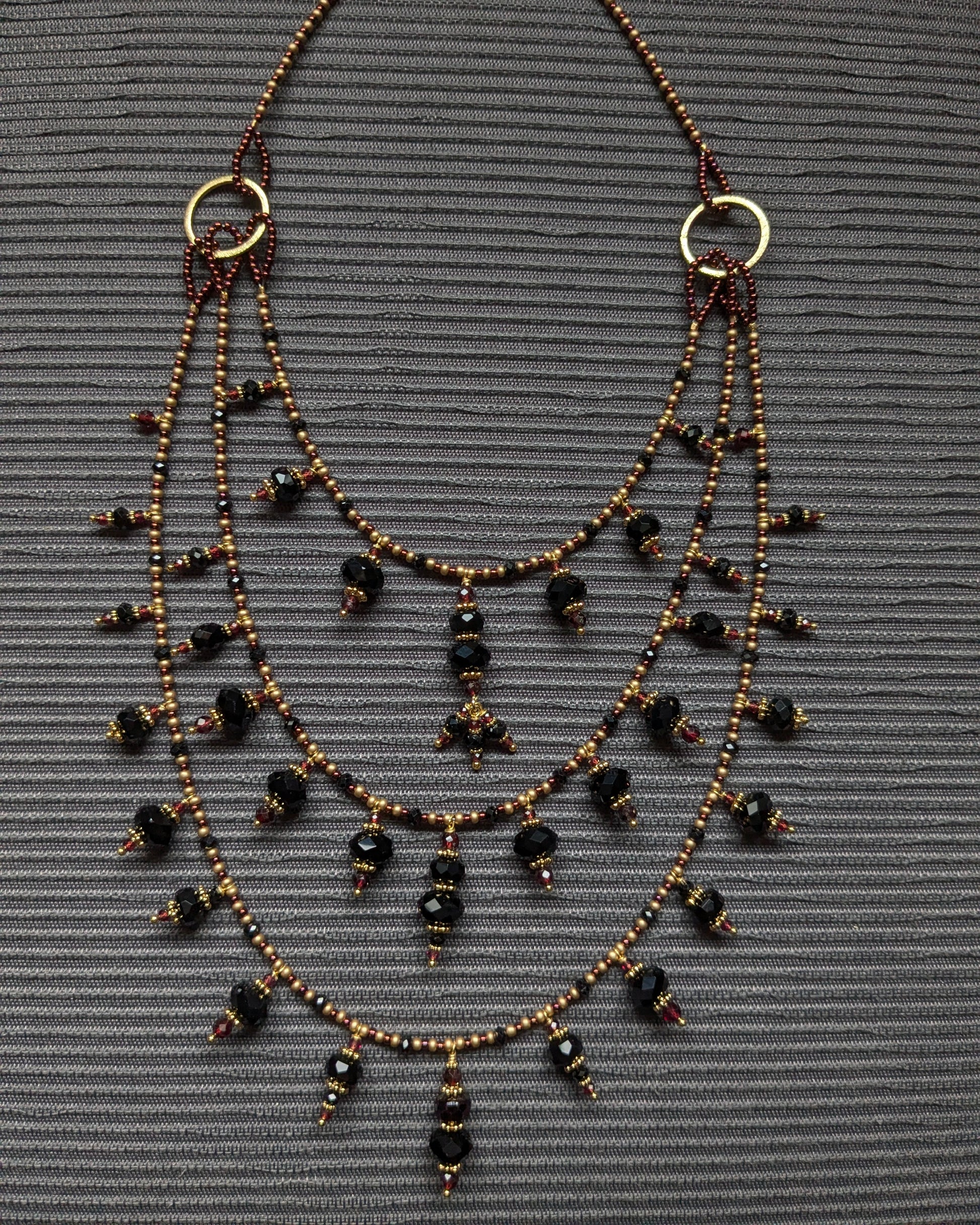 Détail des perles d'onyx facetté et de la tourmaline noire sur le montage multi-rangs d'Aarivya.