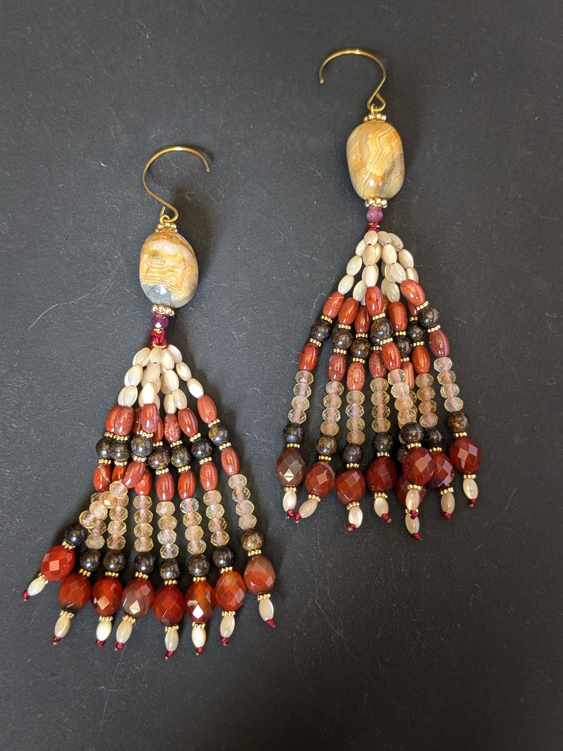 Pendants d'oreilles Anika posés sur un présentoir, agate mexicaine, grenat, bronzite et citrine