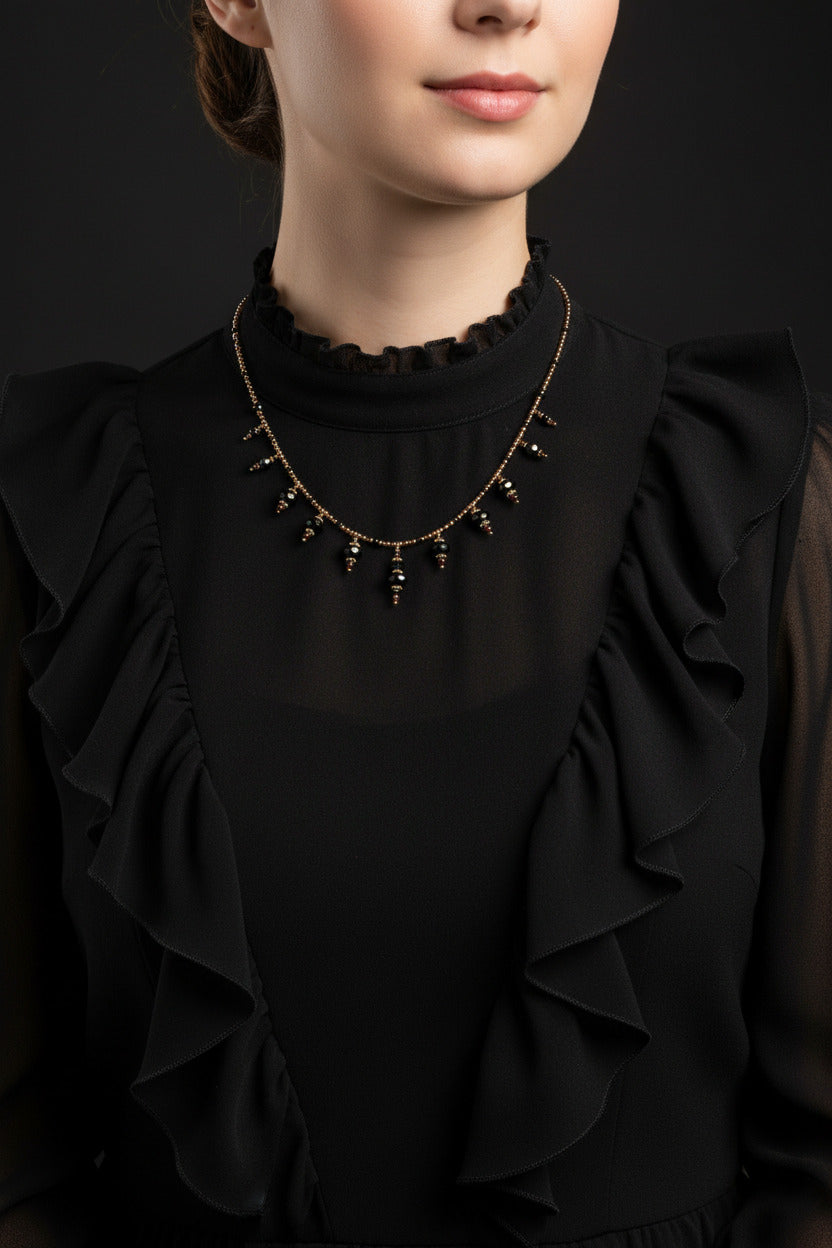 Le collier Bhavika porté à la base du cou, illustrant sa ligne sombre, précise et aérienne.