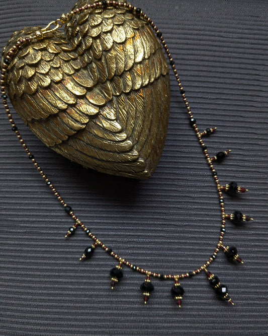 Collier Onyx et Grenat, franges d’onyx noir facetté, tourmaline noire, obsidienne et éclats de grenat rouge sombre, rocailles japonaises bronze et bordeaux, pièce unique élégante et subtile.