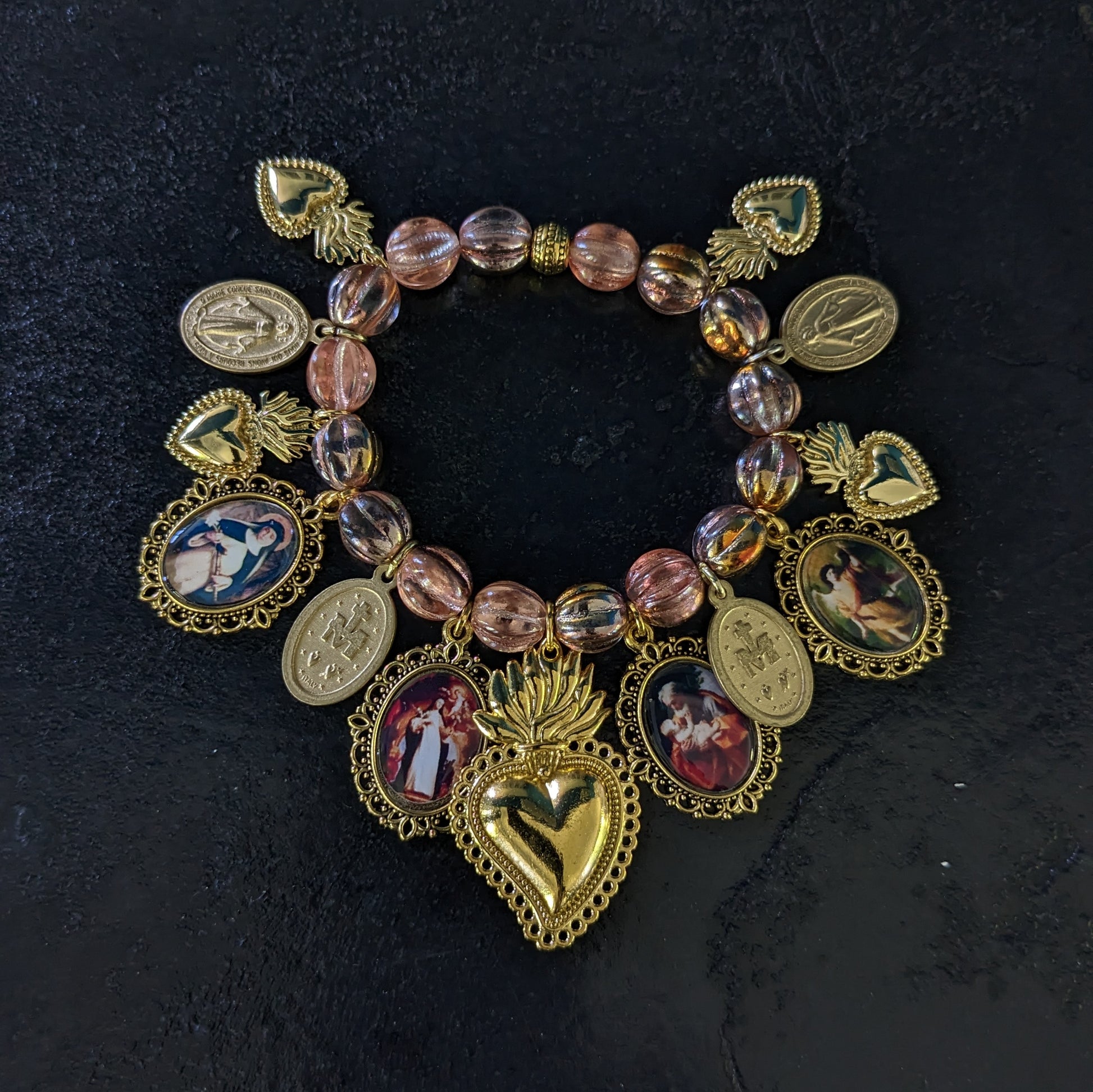 Fait à la main, ce bracelet élégant est orné de médailles catholiques richement détaillées et colorées, et ponctué de médailles miraculeuses.