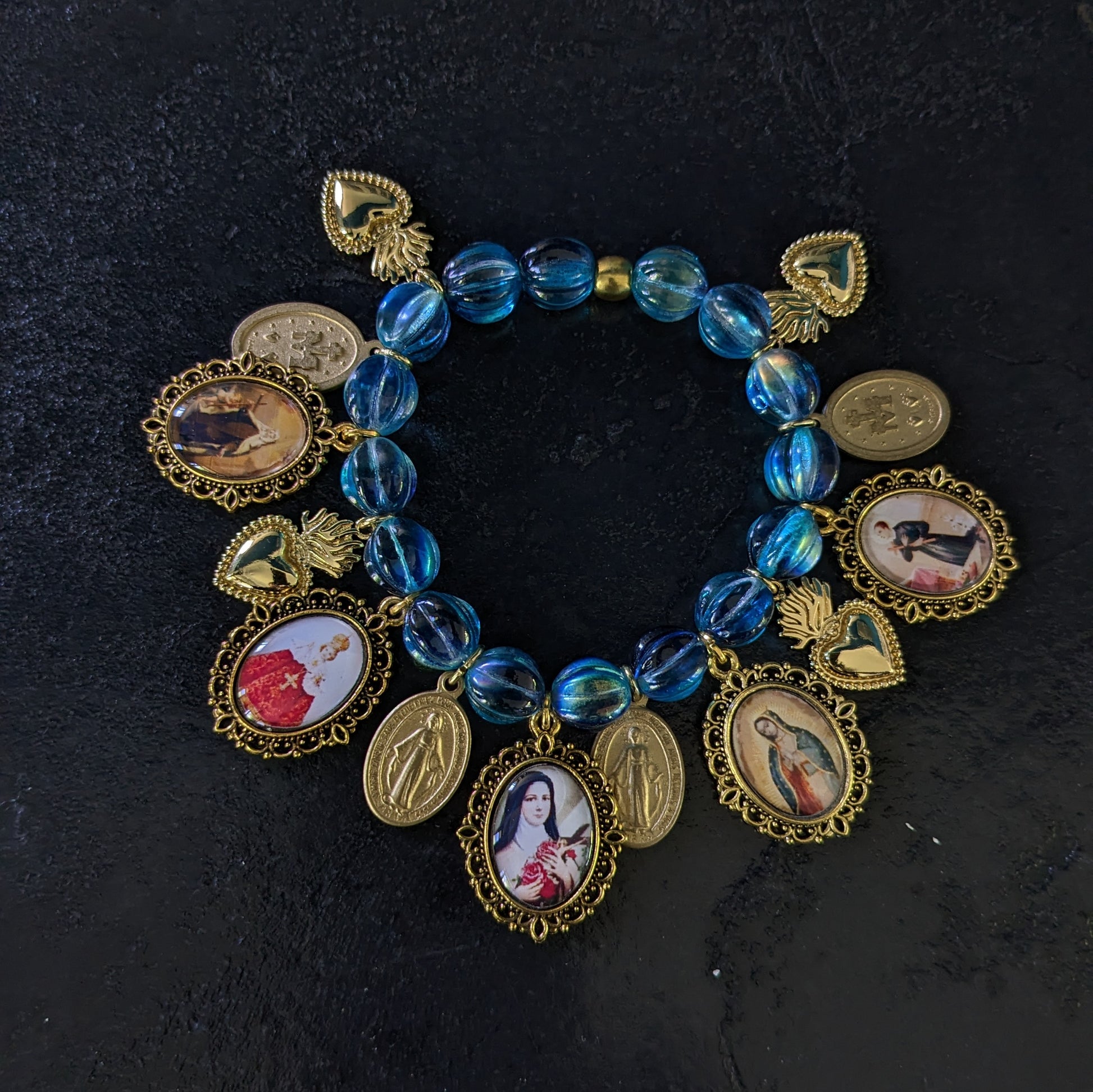 Fait à la main, ce bracelet élégant est orné de médailles catholiques richement détaillées et colorées, et ponctué de médailles miraculeuses.