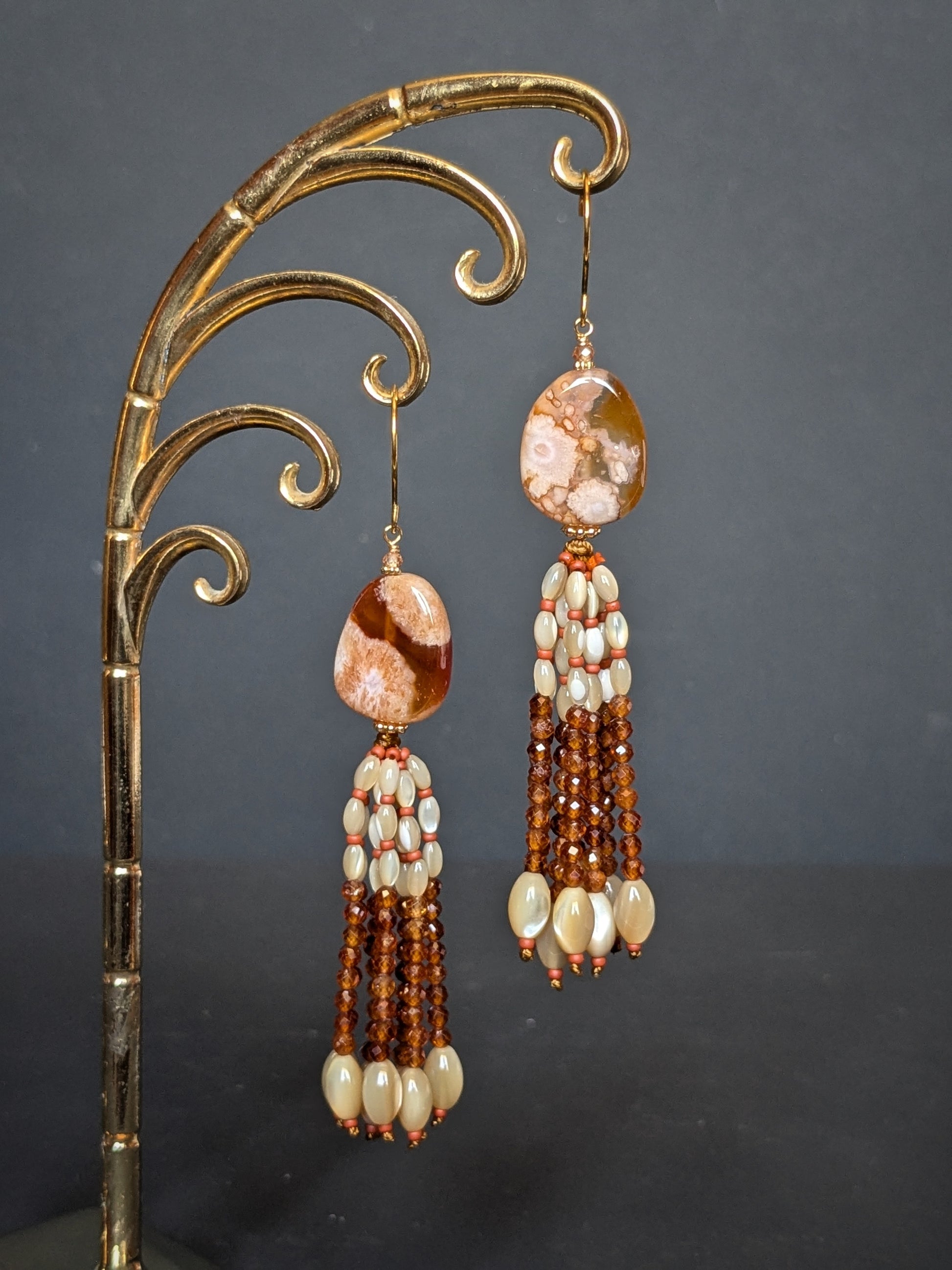 Paire de pendants d'oreilles Chameli posée à plat, agate sakura et tassel de grenats orange