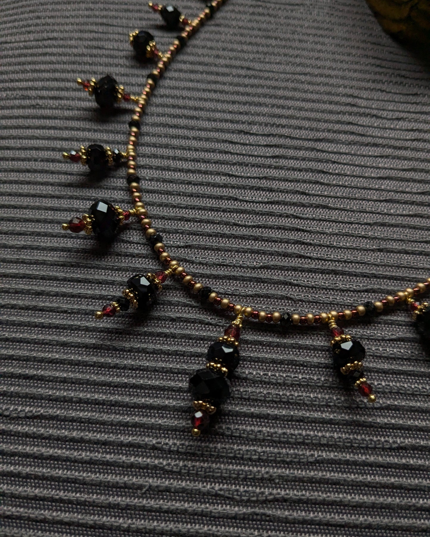 Mouvement discret des breloques minérales noires montées sur laiton doré à patine douce.