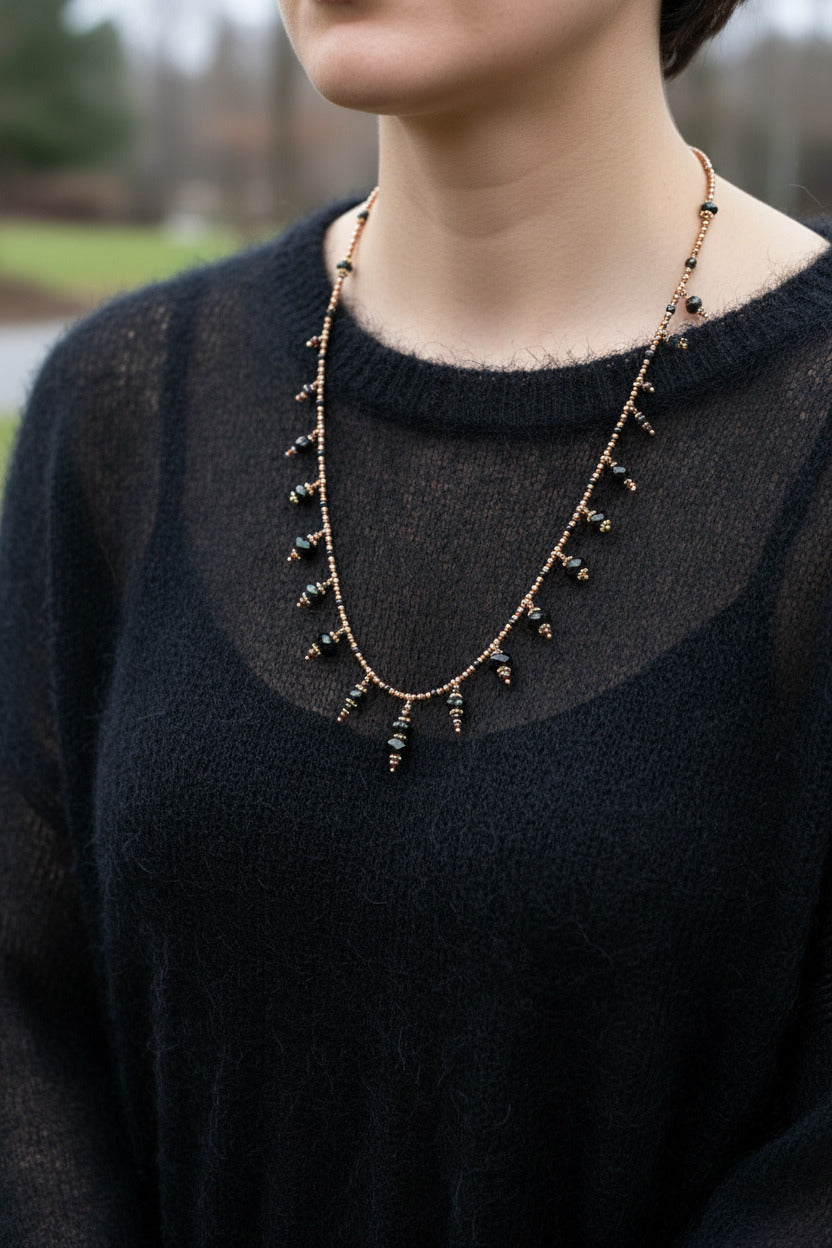 Le collier Chayara porté au niveau du sternum, illustrant sa verticalité stable et sa ligne sombre.