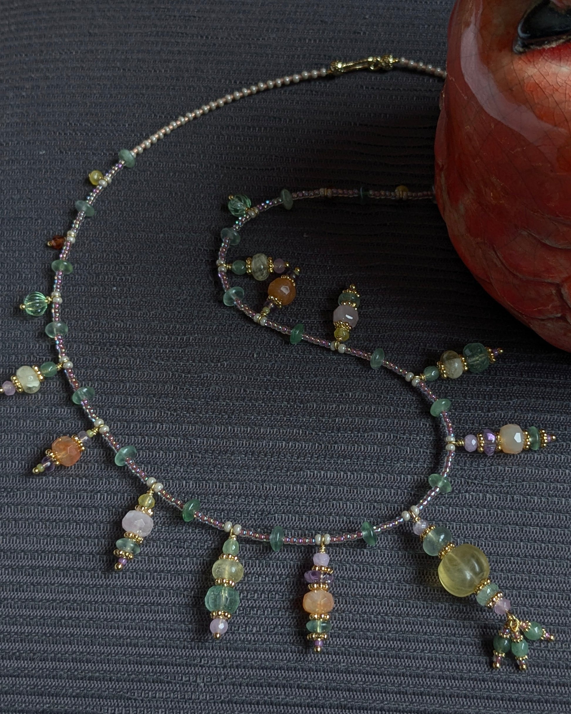 Contrastes entre l'améthyste violette, le quartz fraise vert et les finitions en laiton plaqué or 18kt.