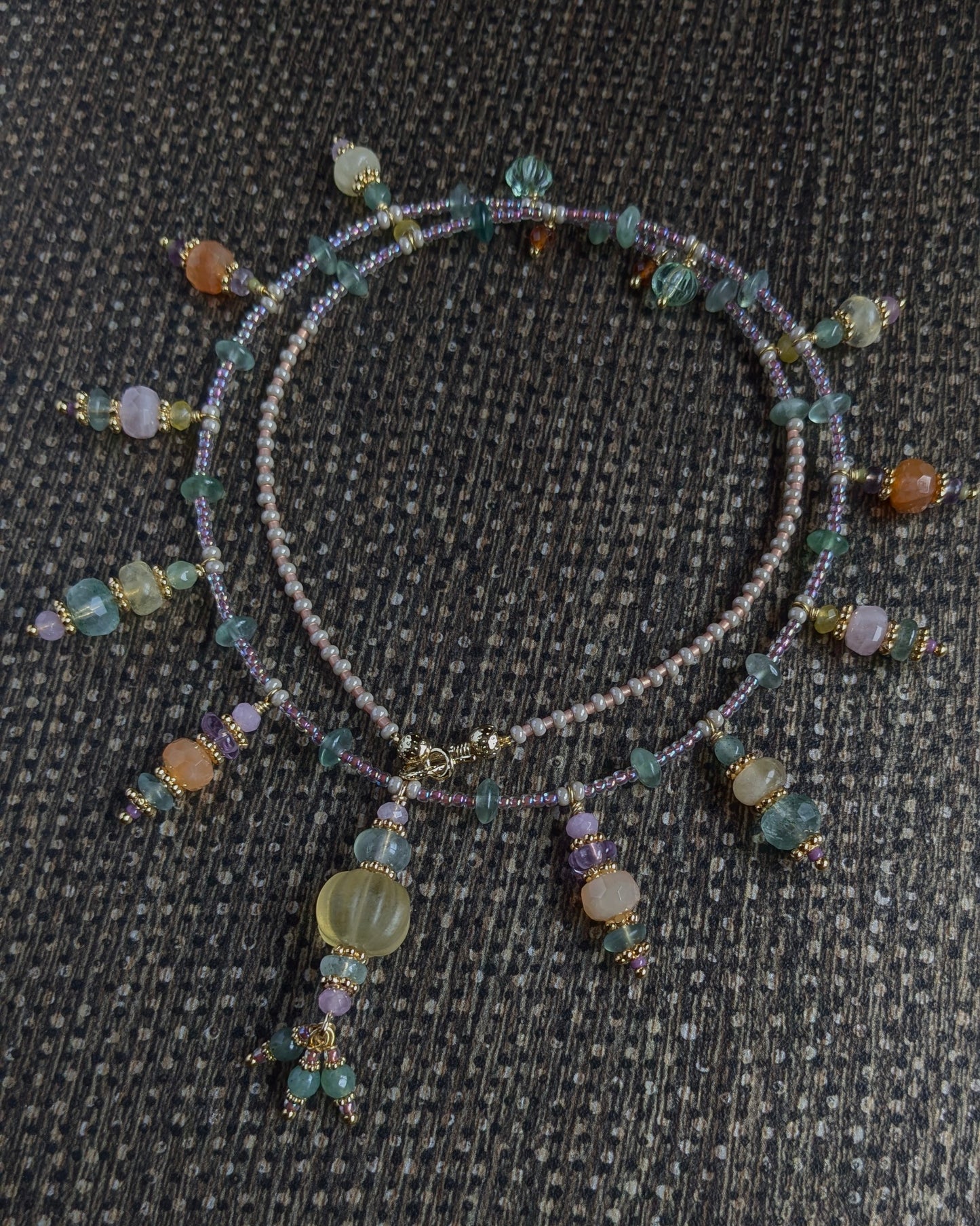 Détail des nuances de jade vert, jade mauve et fluorite jaune sur le collier artisanal Gaurini