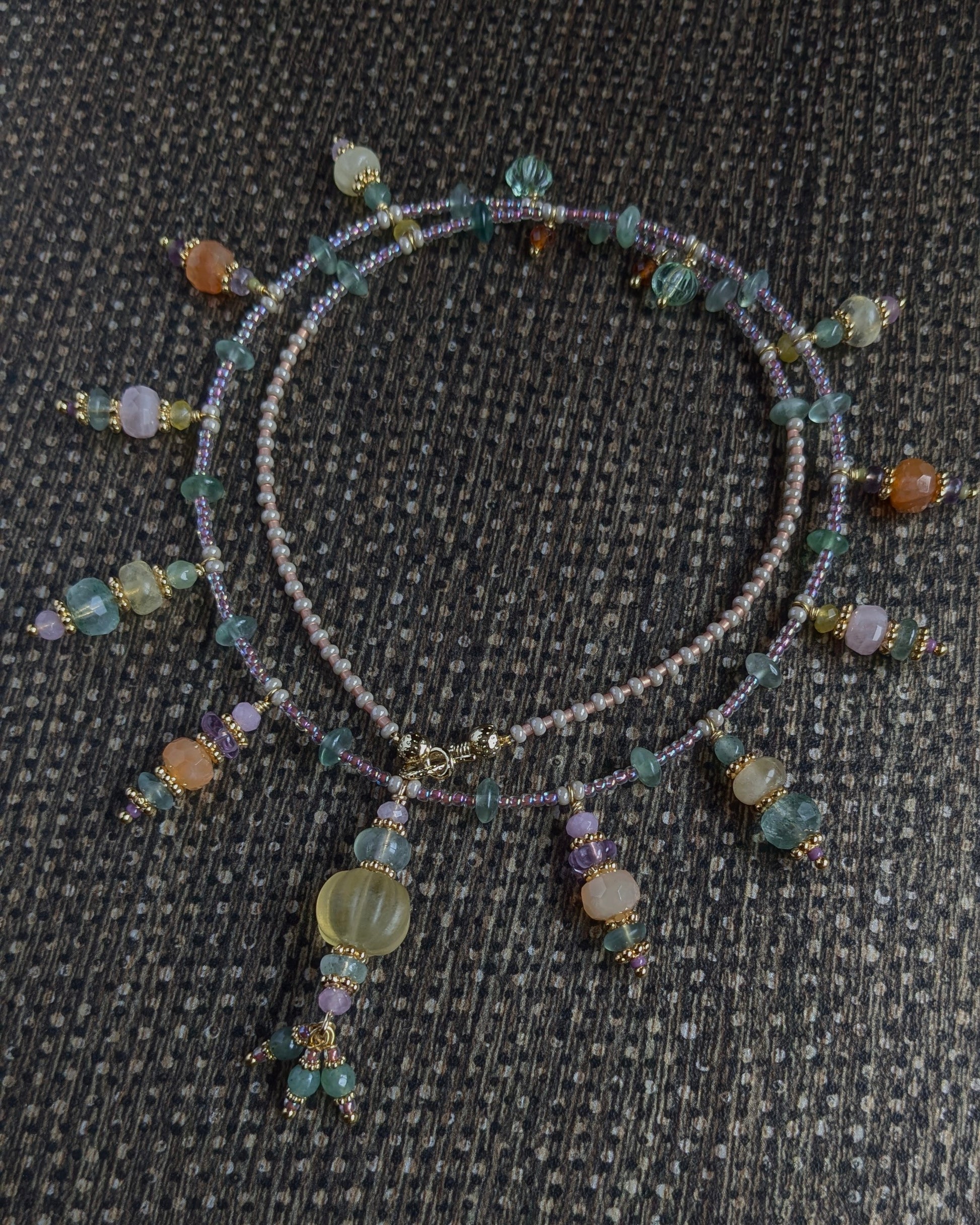 Détail des nuances de jade vert, jade mauve et fluorite jaune sur le collier artisanal Gaurini
