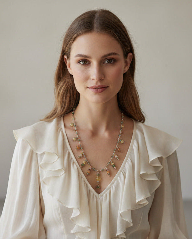 Le collier long Gaurini porté, illustrant son tombé souple et sa symétrie de couleurs douces.