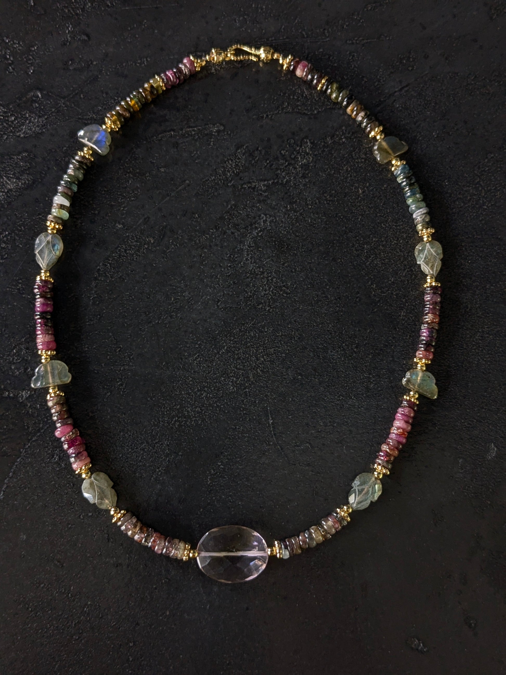Gros plan sur les tourmalines roses, vertes, bleues et autres pierres fines du collier Mudra, révélant la diversité des couleurs et la qualité des gemmes.