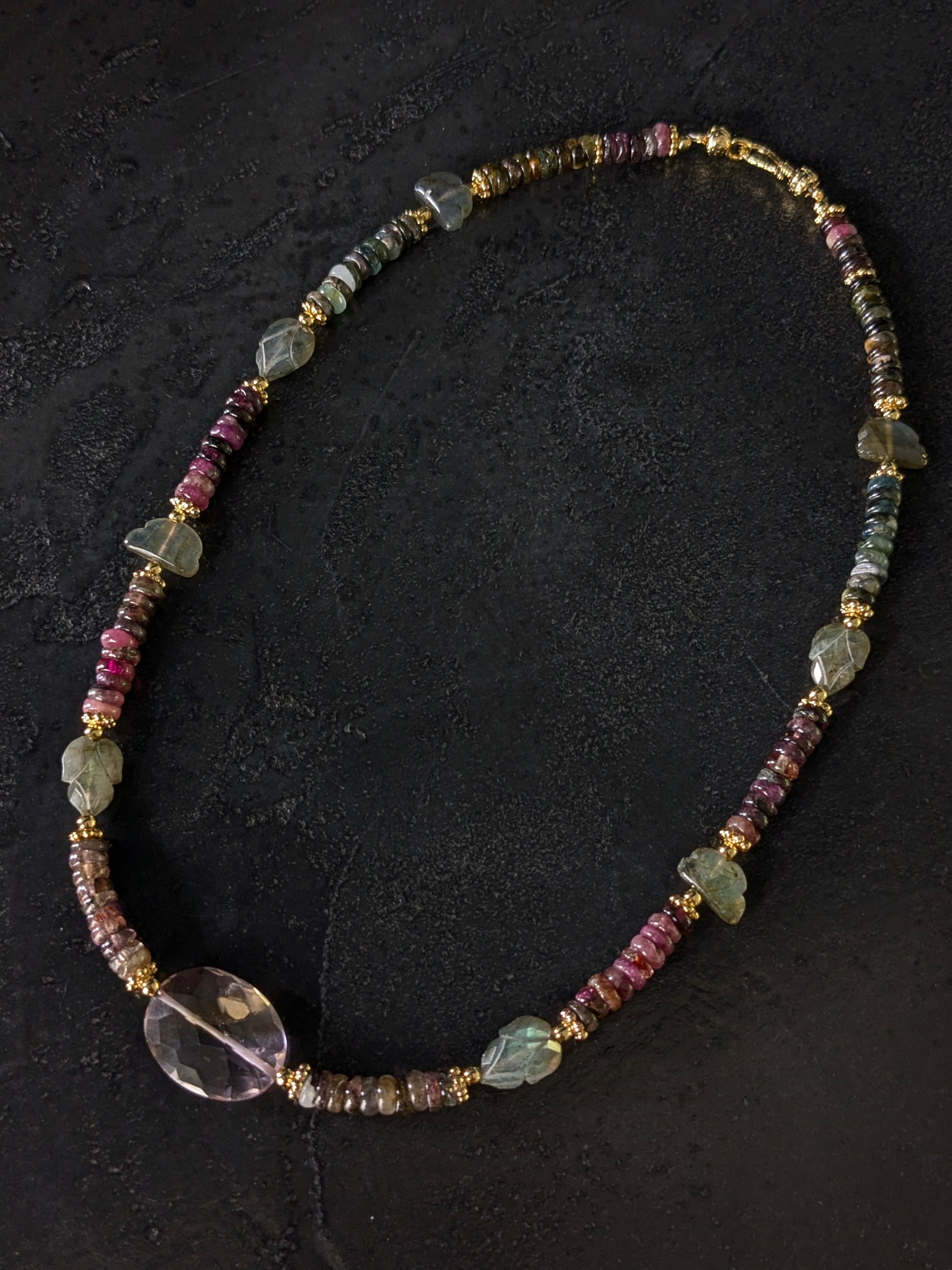 Gros plan sur les tourmalines roses, vertes, bleues et autres pierres fines du collier Mudra, révélant la diversité des couleurs et la qualité des gemmes.