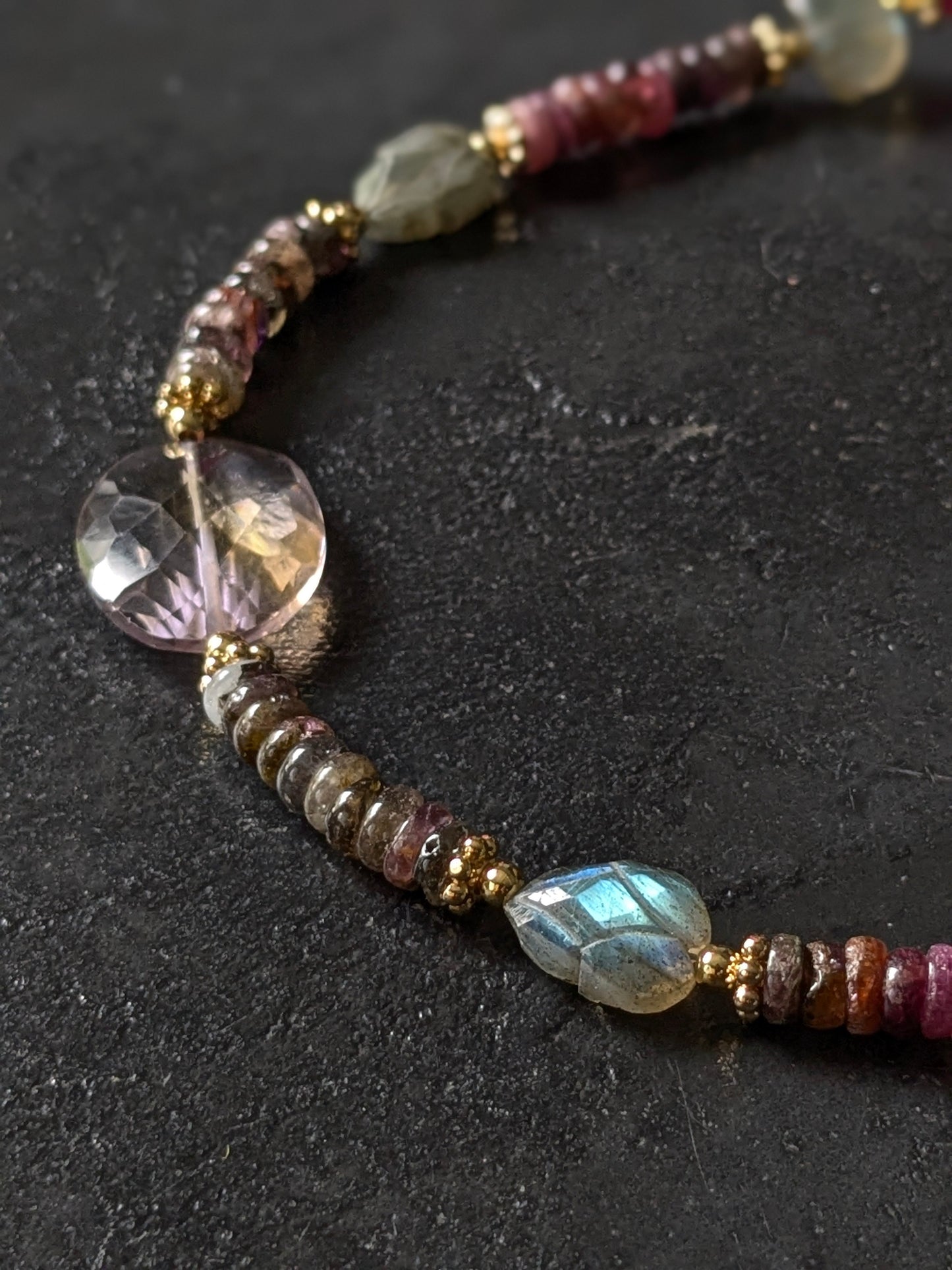 Gros plan sur les tourmalines roses, vertes, bleues et autres pierres fines du collier Mudra, révélant la diversité des couleurs et la qualité des gemmes.