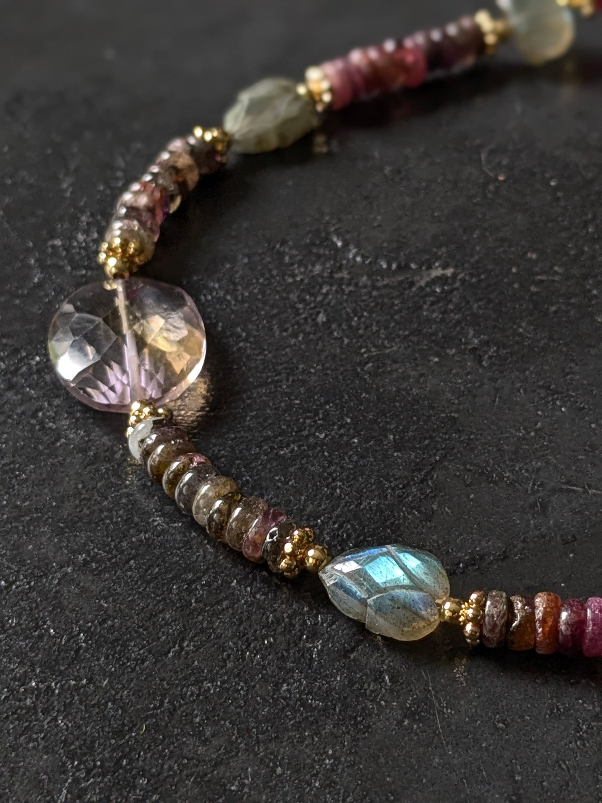 Gros plan sur les tourmalines roses, vertes, bleues et autres pierres fines du collier Mudra, révélant la diversité des couleurs et la qualité des gemmes.
