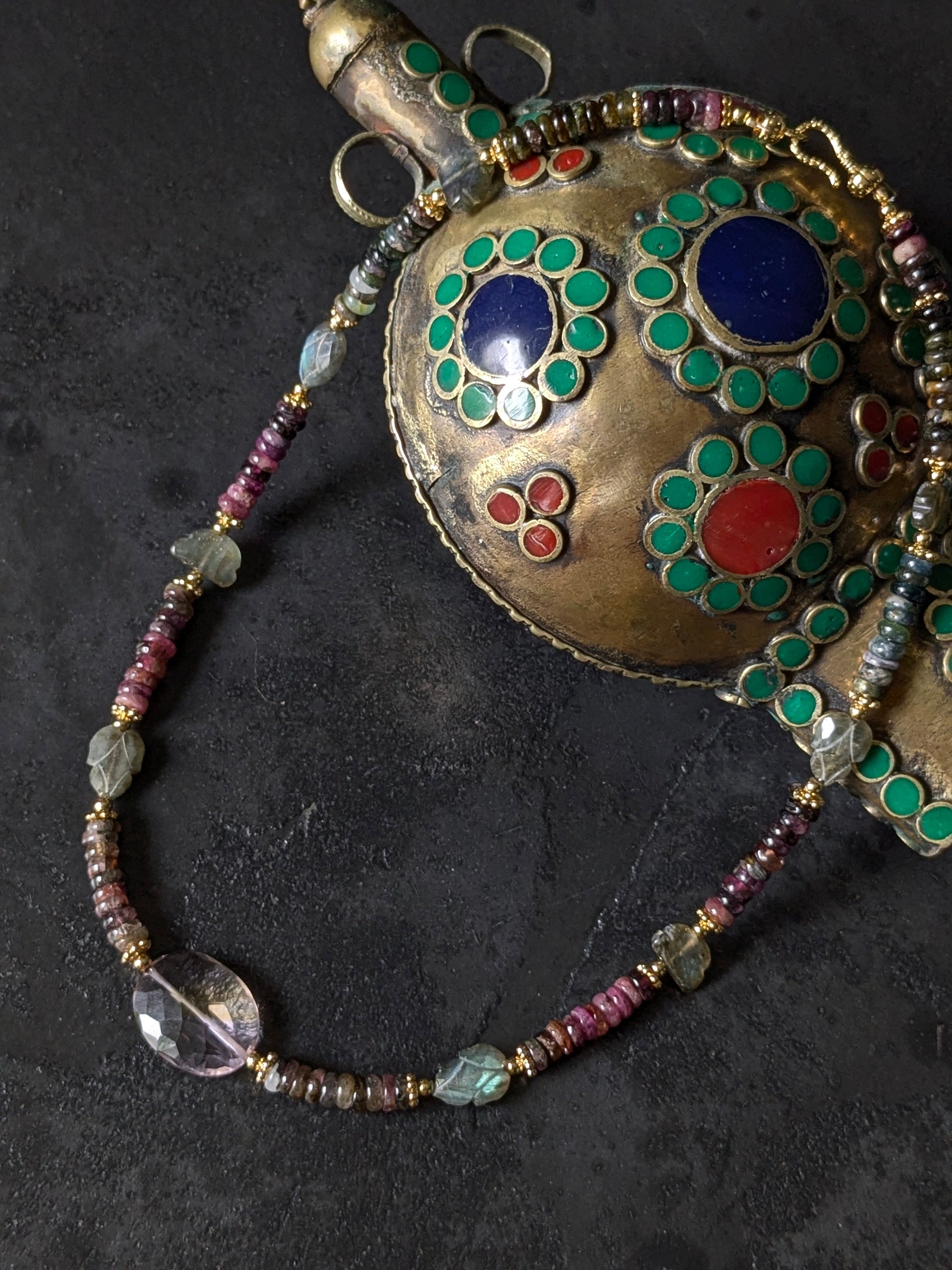 Gros plan sur les tourmalines roses, vertes, bleues et autres pierres fines du collier Mudra, révélant la diversité des couleurs et la qualité des gemmes.