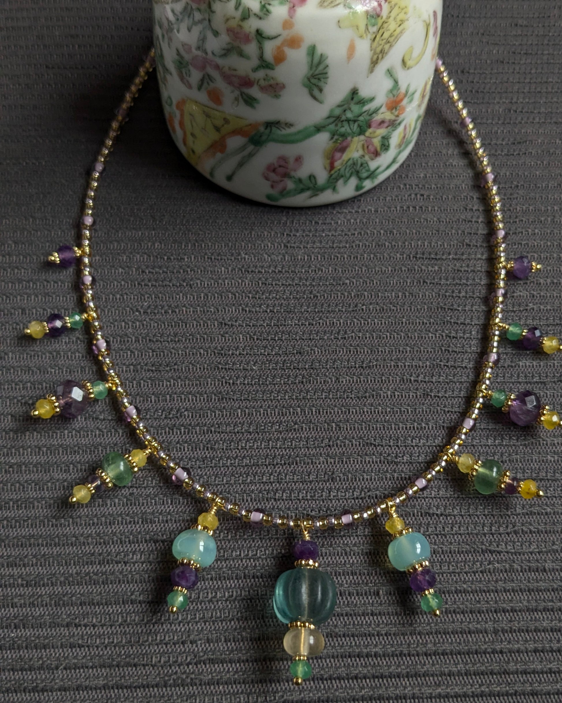 Collier Eshvara, ras de cou 38–40 cm, breloques d’améthyste violette, fluorite verte, jade jaune et vert et calcédoine aqua, rocailles Miyuki or pâle, pièce unique, élégante et aérienne.