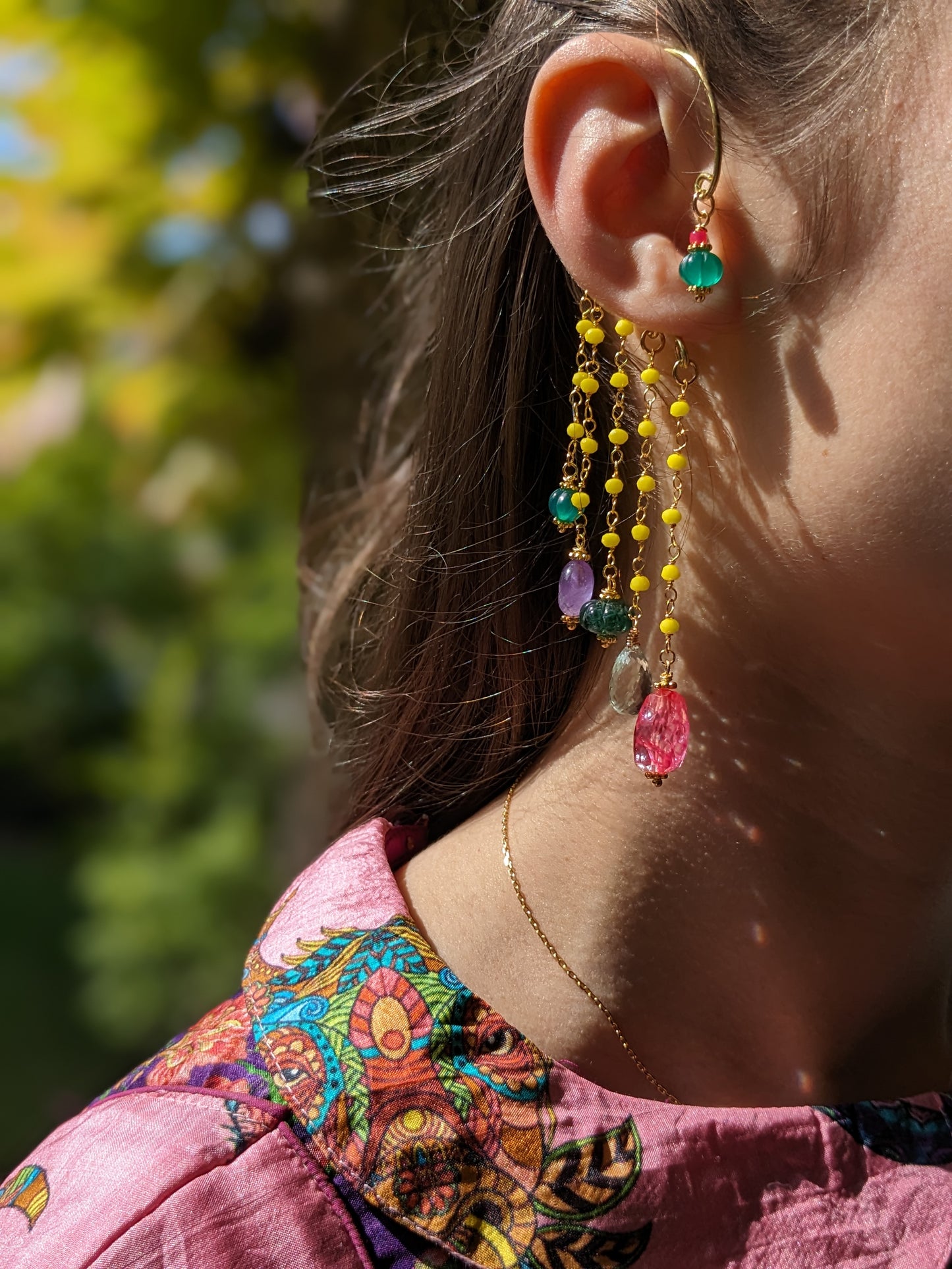 Boucles d'oreilles 'Goa' méticuleusement conçues, mettant en vedette une gravure sur onyx vert, des pierres d'agate teintées en rose, des gemmes d'améthyste et d'améthyste verte, complétées par des chaînes ornées de cristaux étincelants. Un hommage vibrant aux couleurs de l'Inde