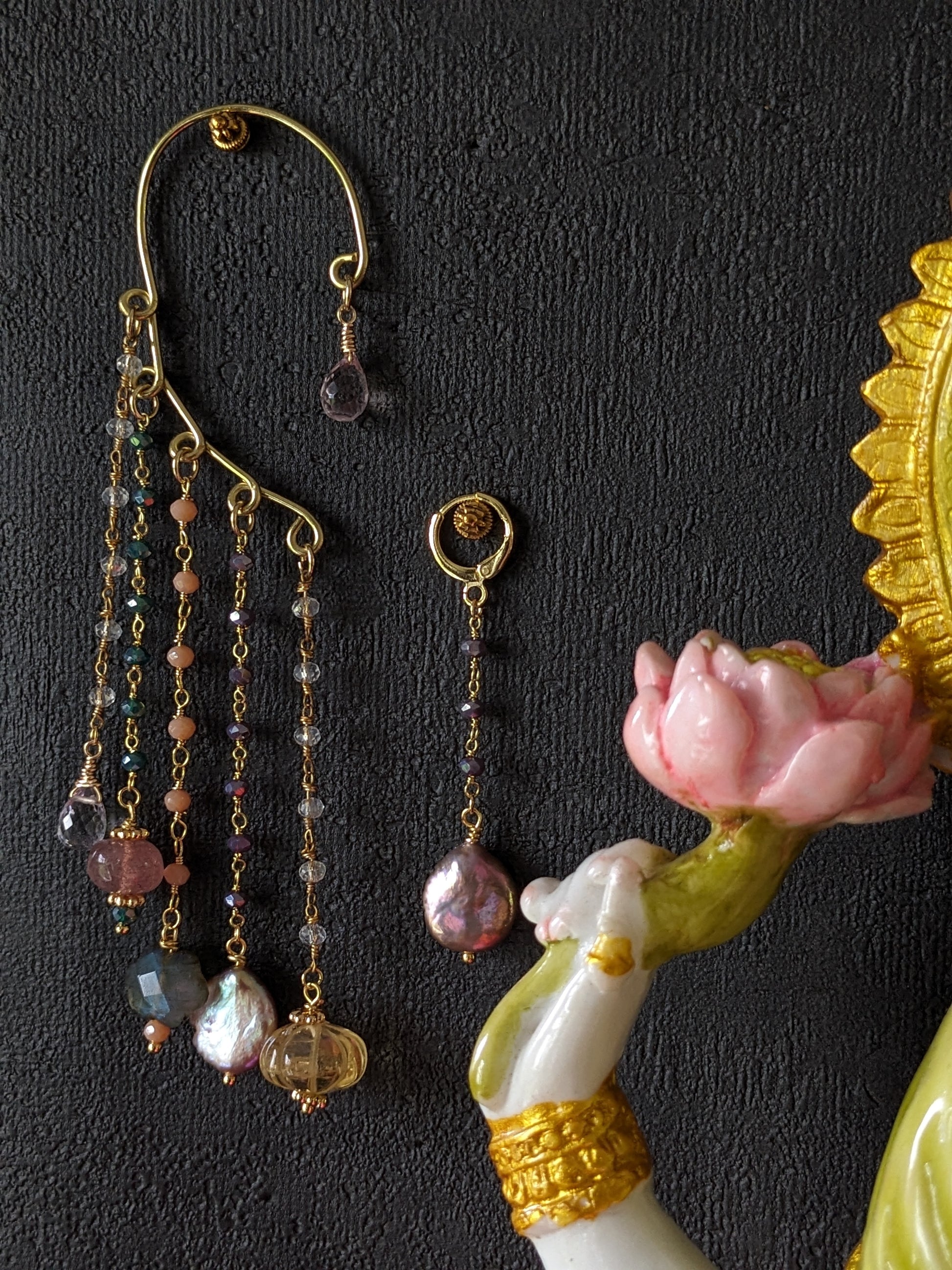 Une paire de boucles d'oreilles pendantes 'Kalamkari', magnifiquement ornées de pierres précieuses colorées comme la briolette améthyste lavande, le quartz fraise, un nuage de labradorite, des perles keshi et la citrine sculptée, reflétant le charme artisanal unique de Jaipur.