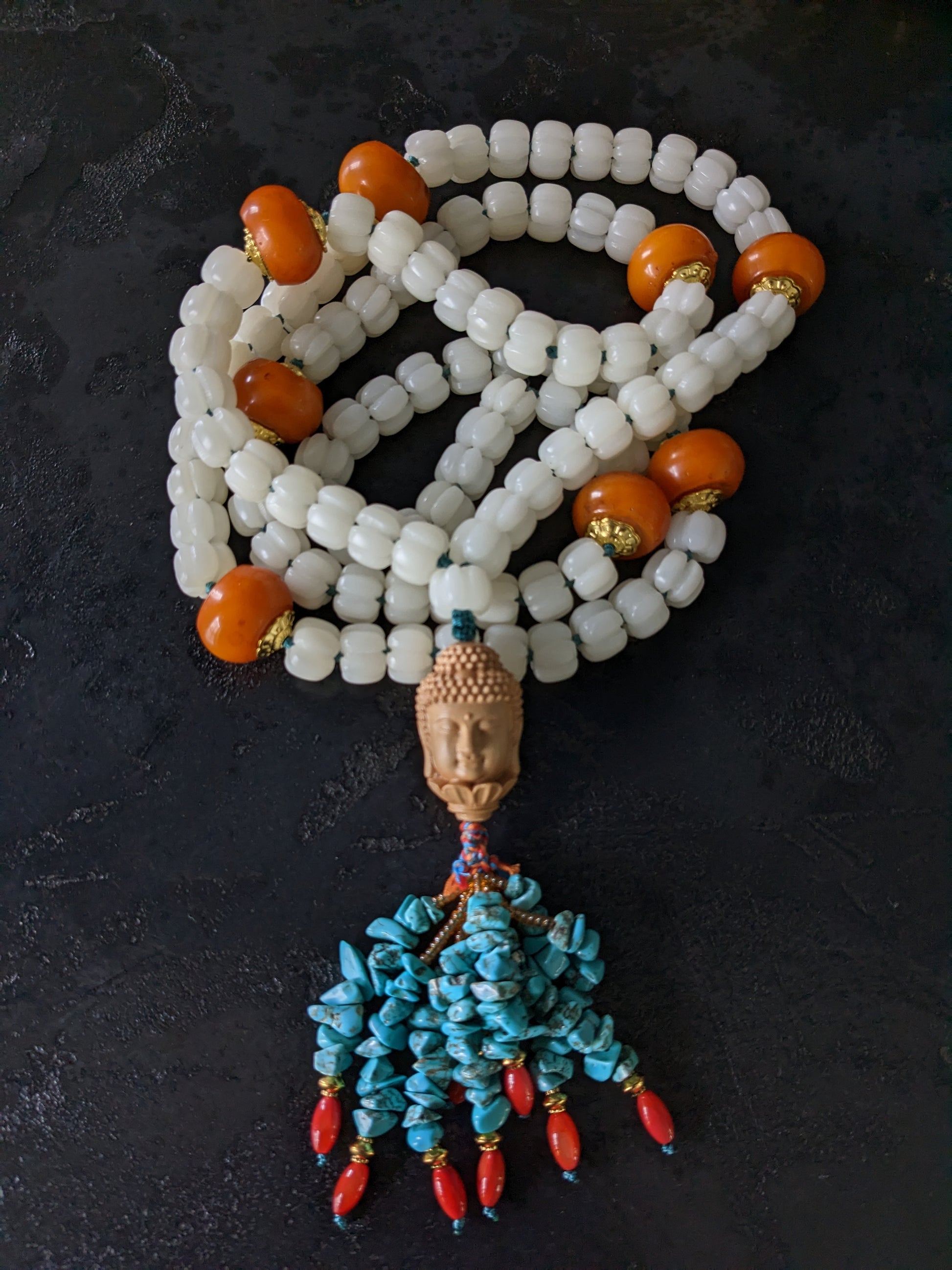 Mala traditionnel tibétain de 108 perles sculptées et orné d'une tête de bouddha sculptée