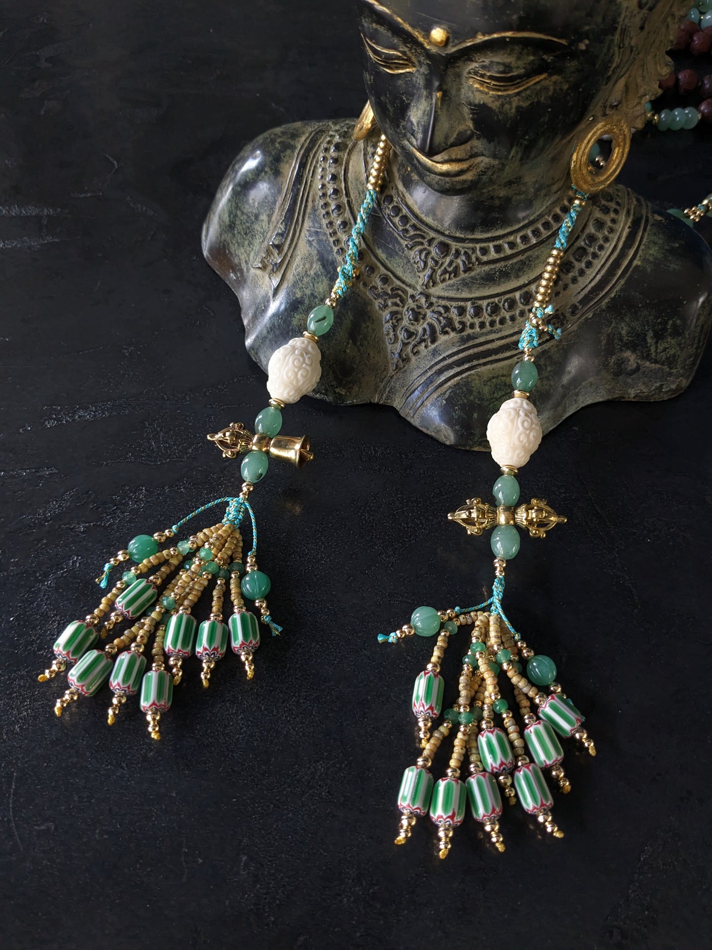 Chapelet bouddhiste Mala Kanchipuram artisanal, orné de perles d'aventurine vertes éclatantes et de bois de santal rouge riche. Un bijou spirituel unique qui respire la chaleur et le savoir-faire.