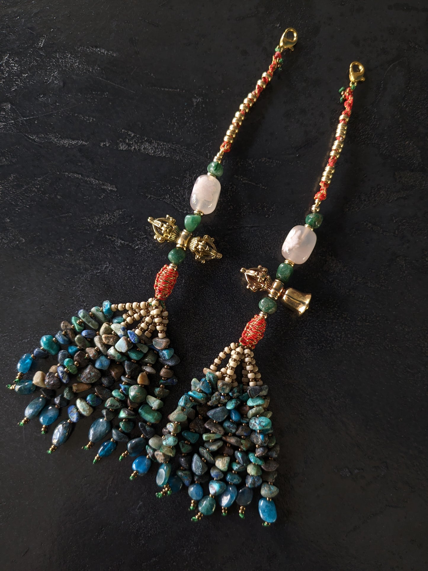 Image captivante du Mala Shambhala, un collier de méditation unique, mettant en valeur ses perles naturelles multicolores et ses compteurs de style tibétain, le tout évoquant une sensation de tranquillité et de profondeur spirituelle.