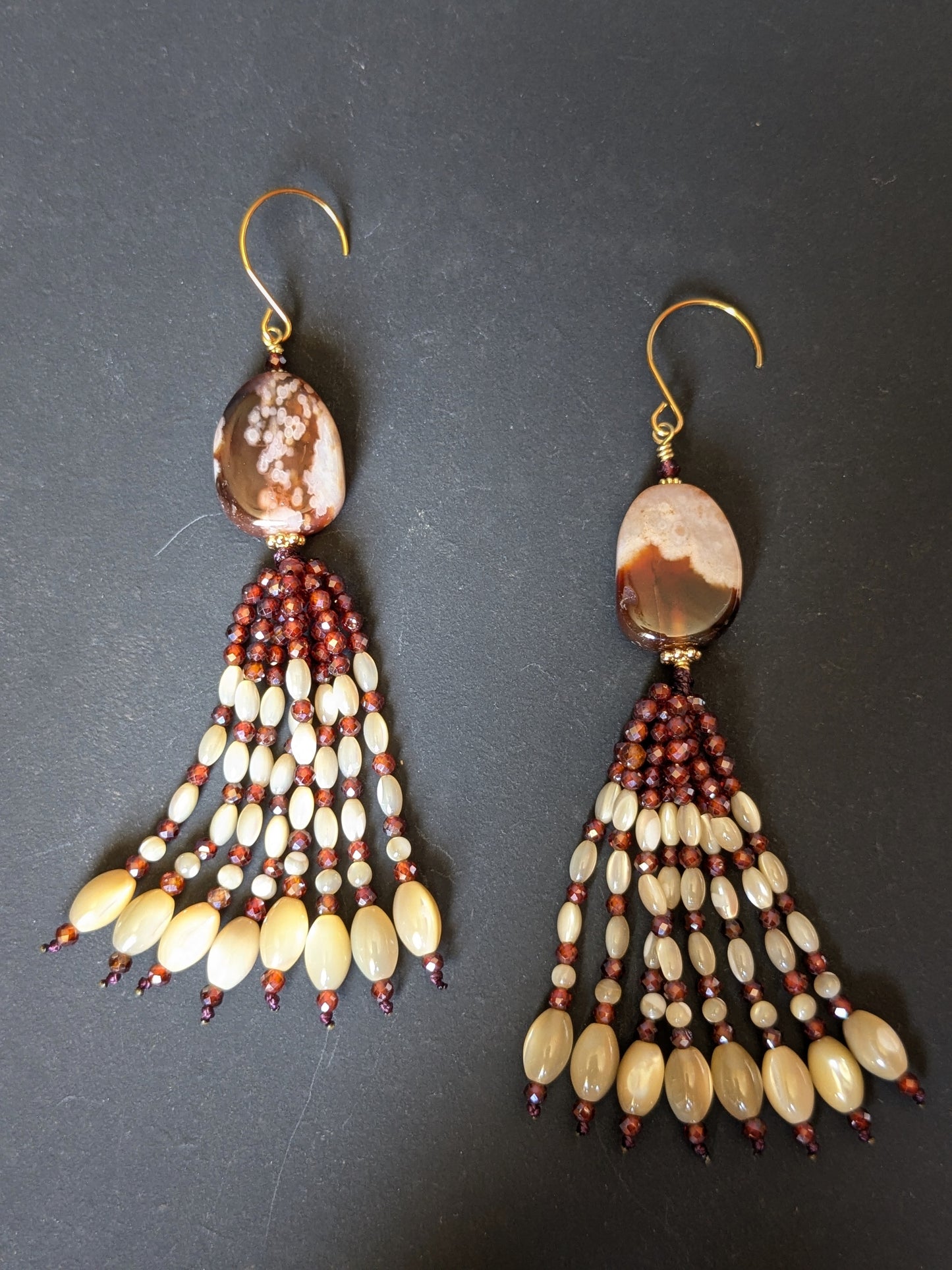 Paire de pendants d'oreilles Mohini posée à plat, agate sakura brun profond et grenats facettés