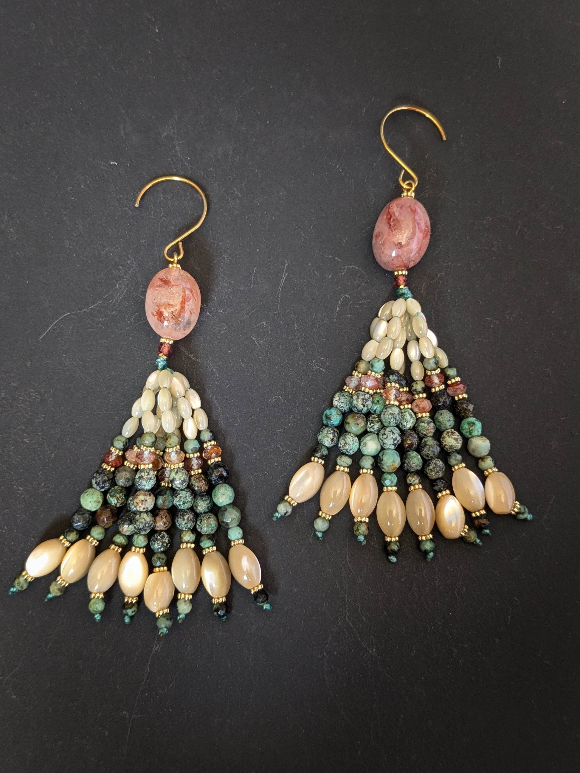 Paire de pendants d'oreilles Naina Mudra posée à plat, quartz hématoïde pêche, nacre, turquoise africaine et grenats en éventail