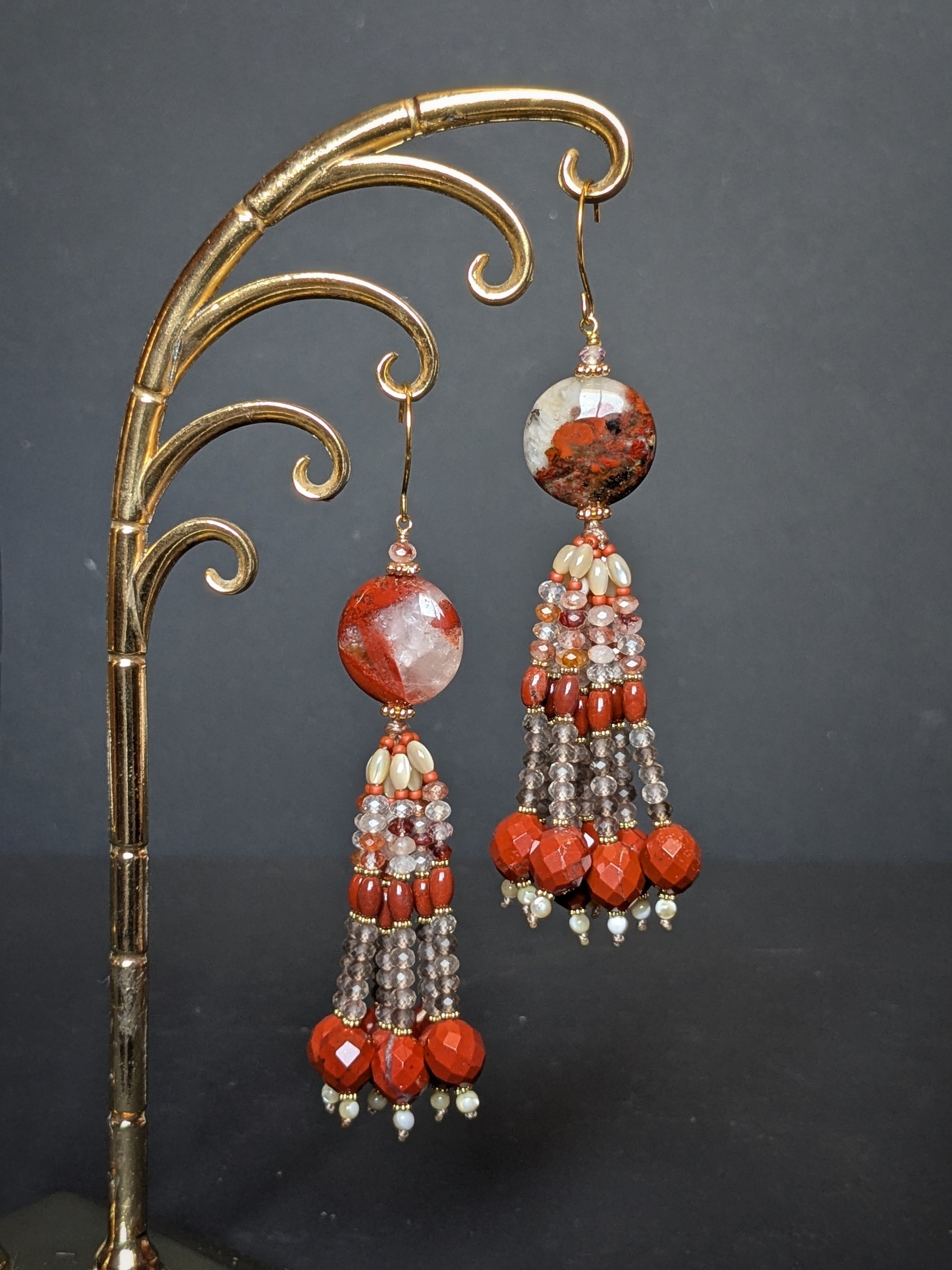 Paire de pendants d'oreilles Nisha posée à plat, disque de jaspe rouge et tassel en quartz facetté