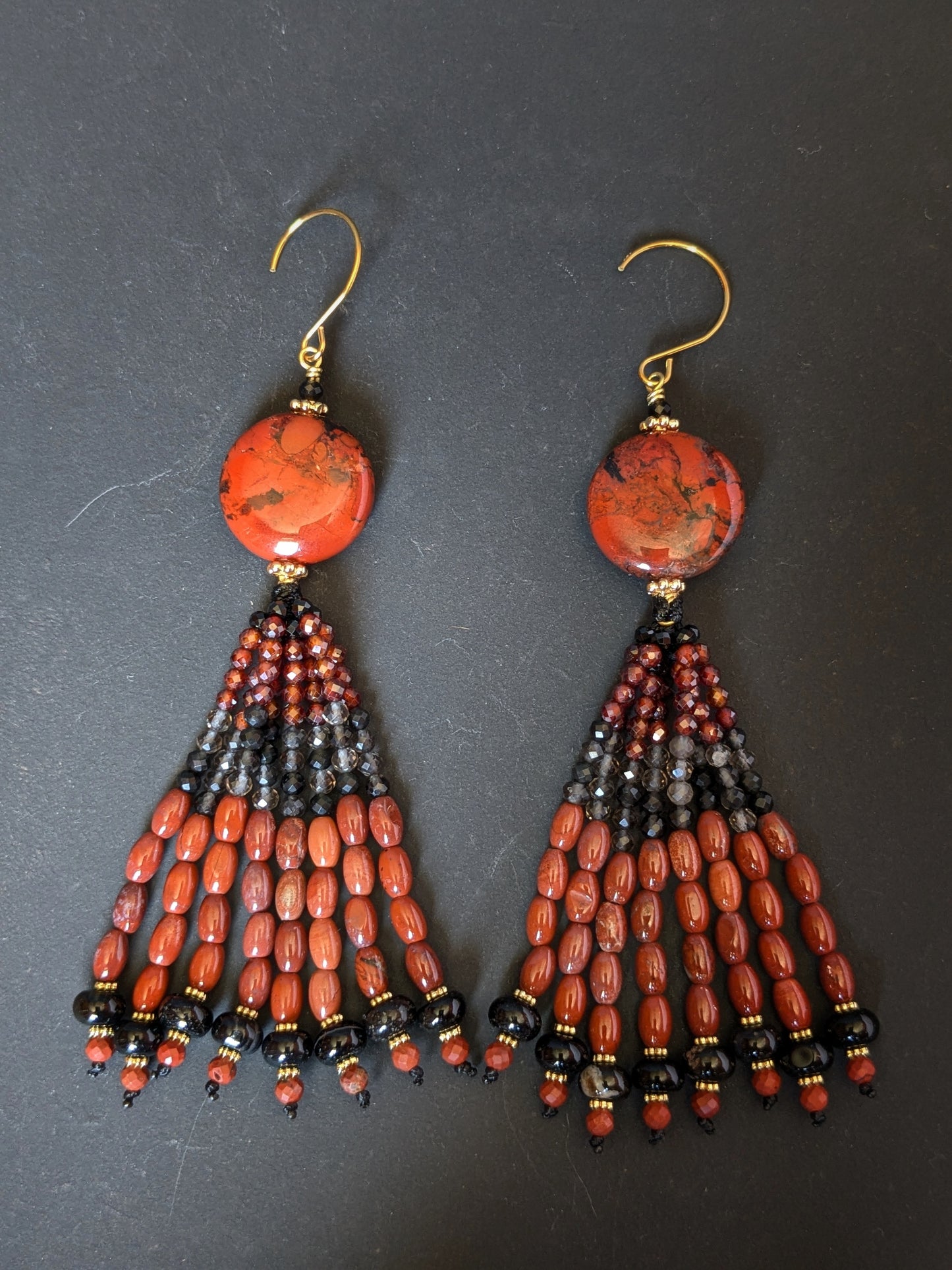 Pendants d'oreilles Simran posés sur un présentoir, jaspe rouge, zircons bordeaux et onyx