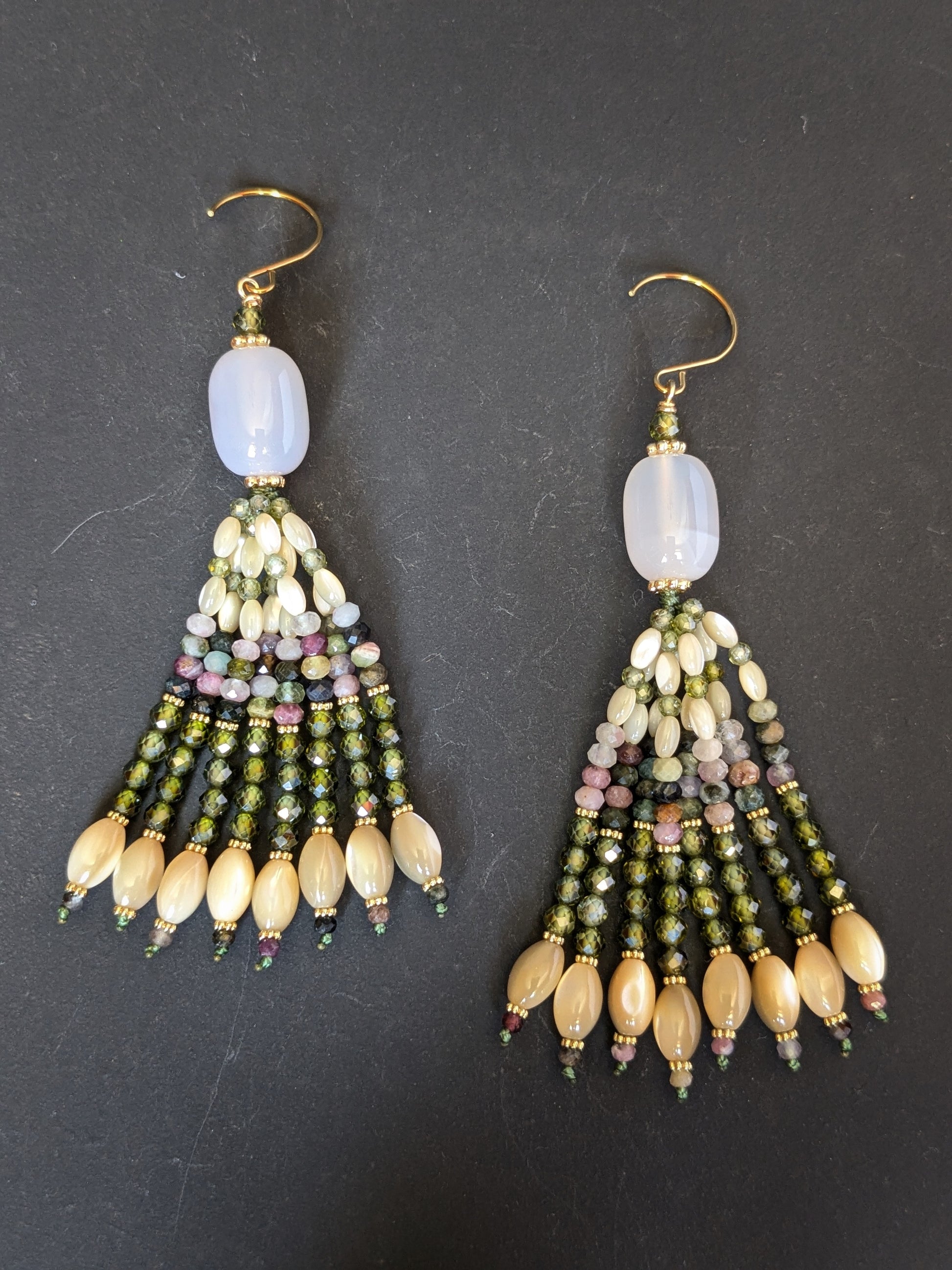 Paire de pendants d'oreilles Aadhya Mudra posés sur un présentoir, calcédoine blanche et tons olive ivoire