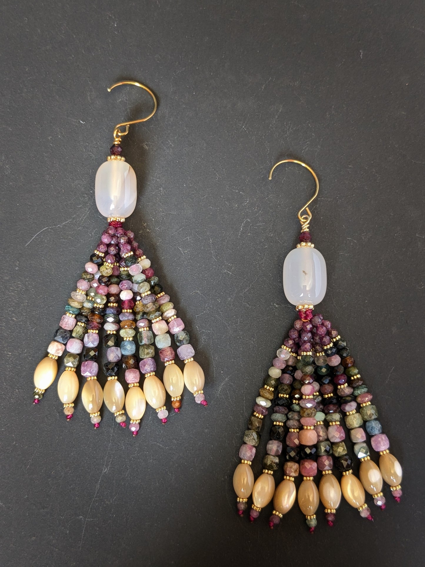 Paire de pendants d'oreilles Ishaani Mudra posés sur un présentoir, calcédoine blanche et tourmaline multicolore