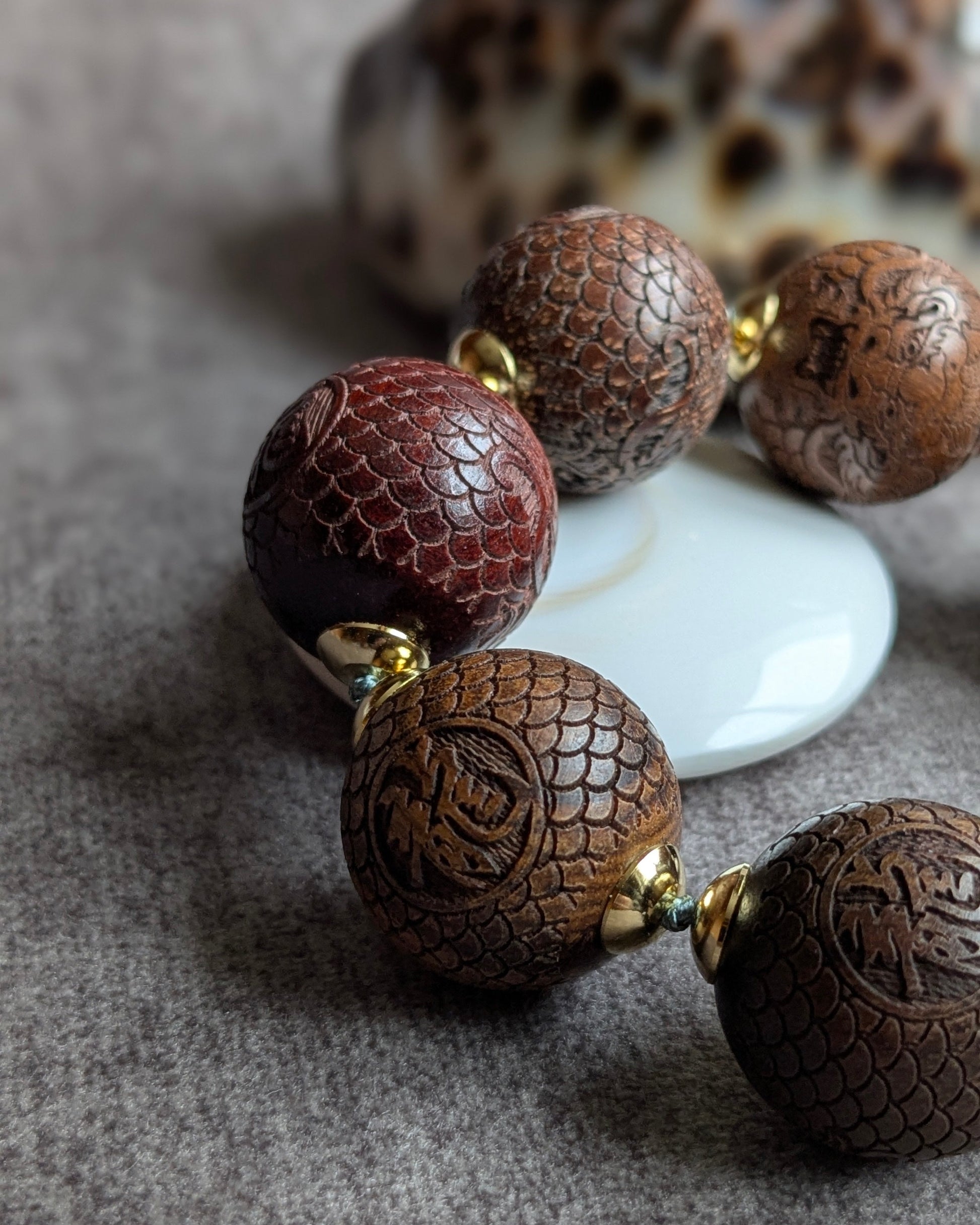 Gros plan perle dragon sculptée 20mm bois chocolat bracelet aravin