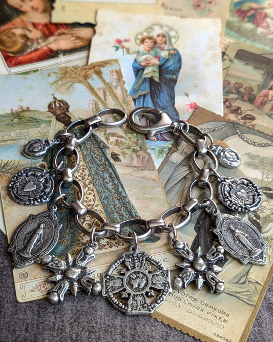 Bracelet maximaliste style ex-voto Ardente de la collection Oh My God avec 9 médailles religieuses argentées en étain patiné sur chaîne épaisse.