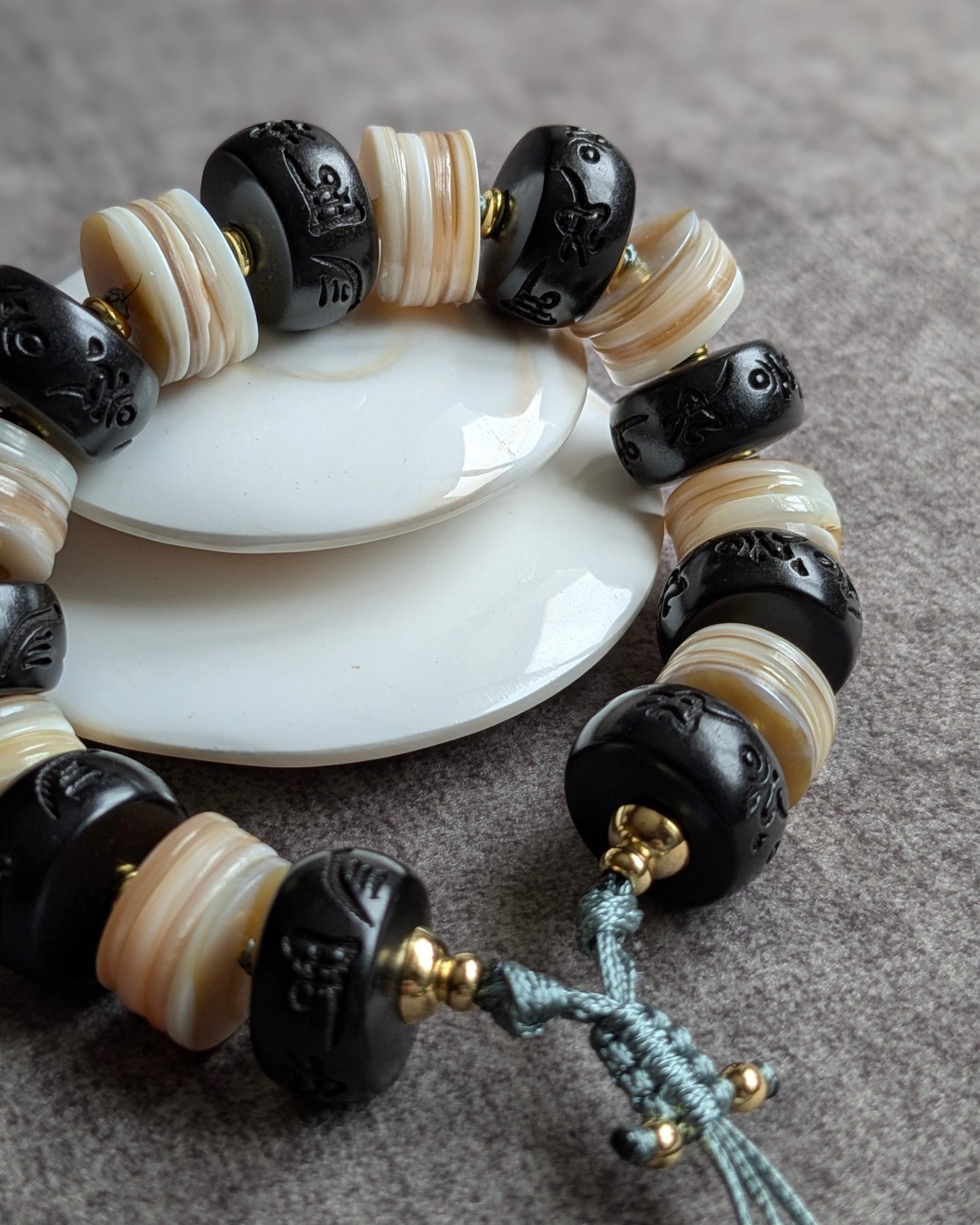 Gros plan gravure mantra bouddhiste sur bois de jujube bracelet devaya