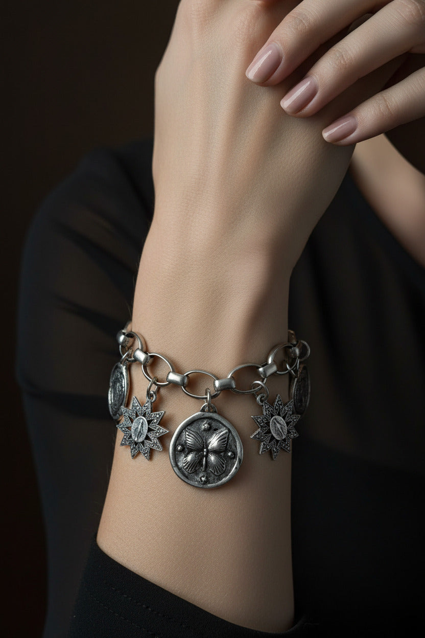 Bracelet Ferveur porté au poignet, une manchette ex-voto au volume affirmé composée de médailles religieuses argentées en accumulation, signée Mudra.